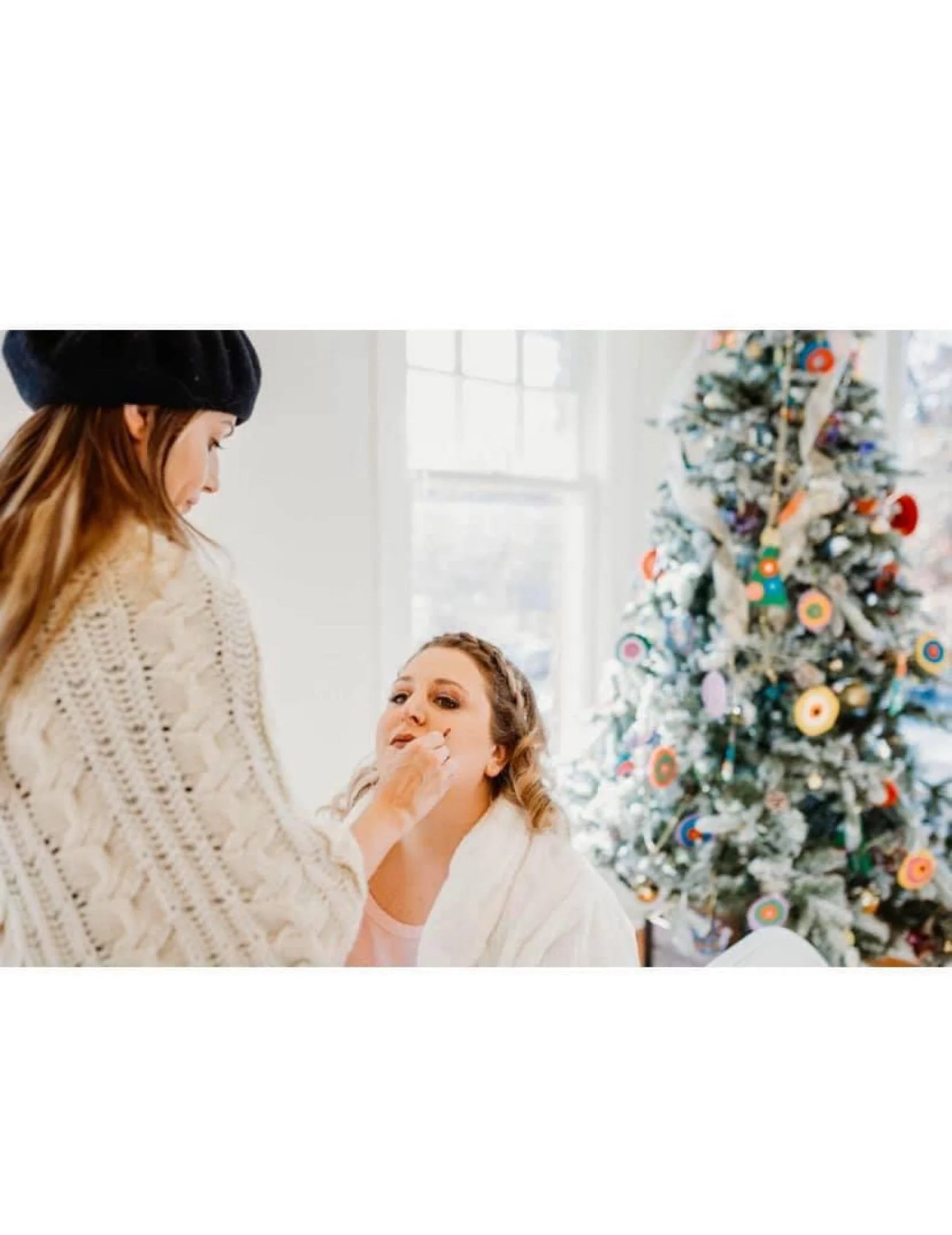 bride getting her makeup done with a christmas tree in the back