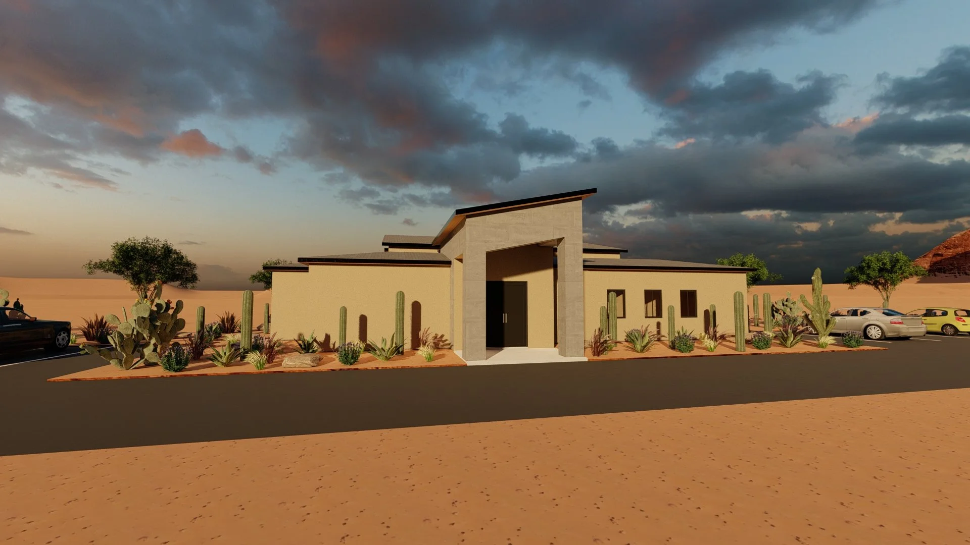 A modern building in a desert landscape with cacti and desert plants, parked cars, and a cloudy sky.