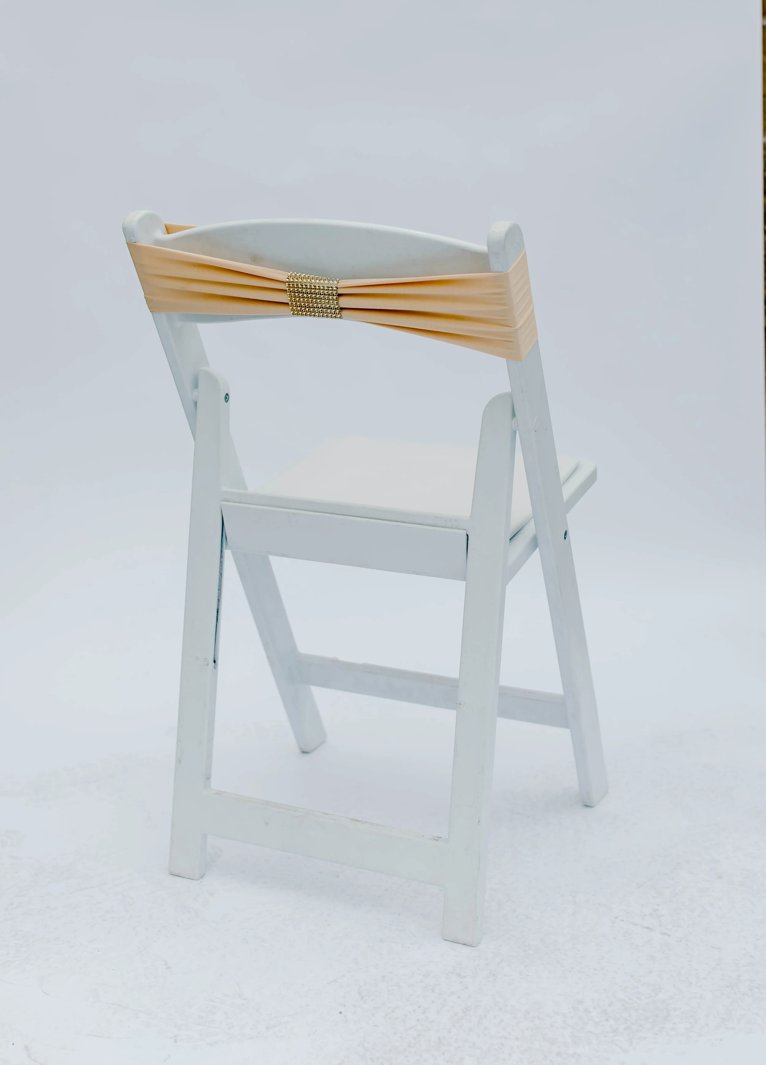 White wooden high chair with a beige ruffle decoration on the backrest