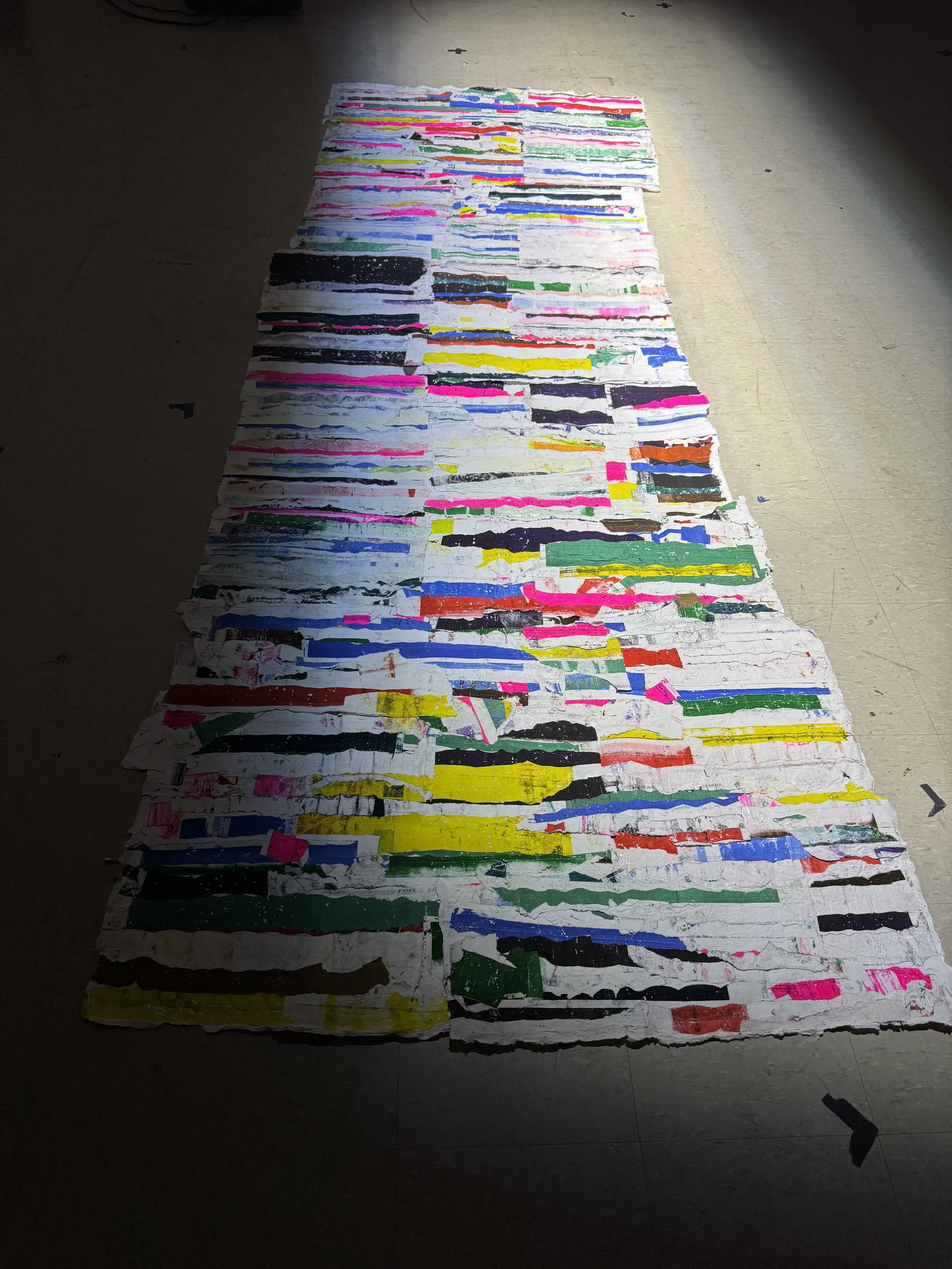 Handmade paper collage from hydraulic press riso stencil transfers (under a spotlight), 2025, 135" x 45"