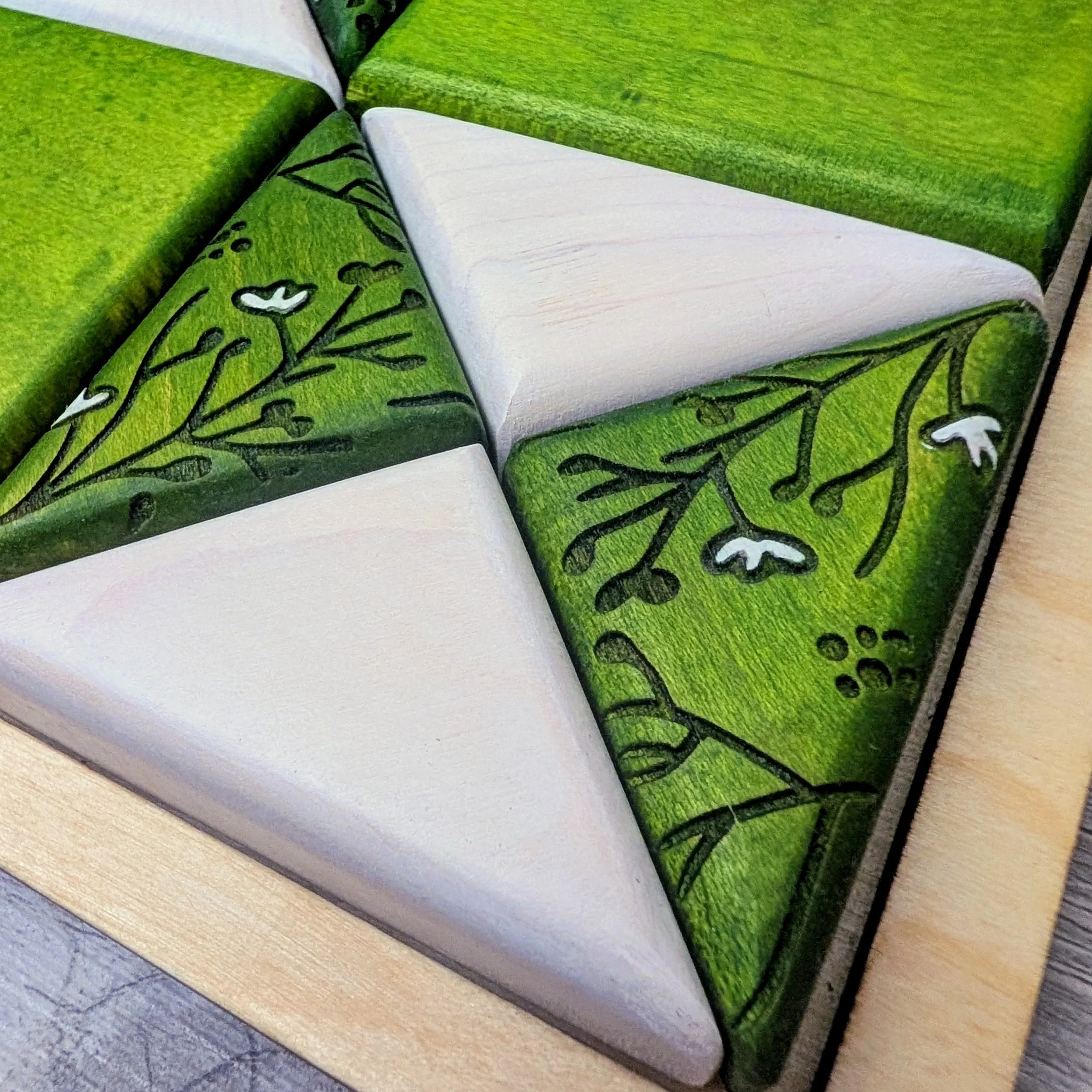 Green and white patterned wooden puzzle featuring bird and floral designs