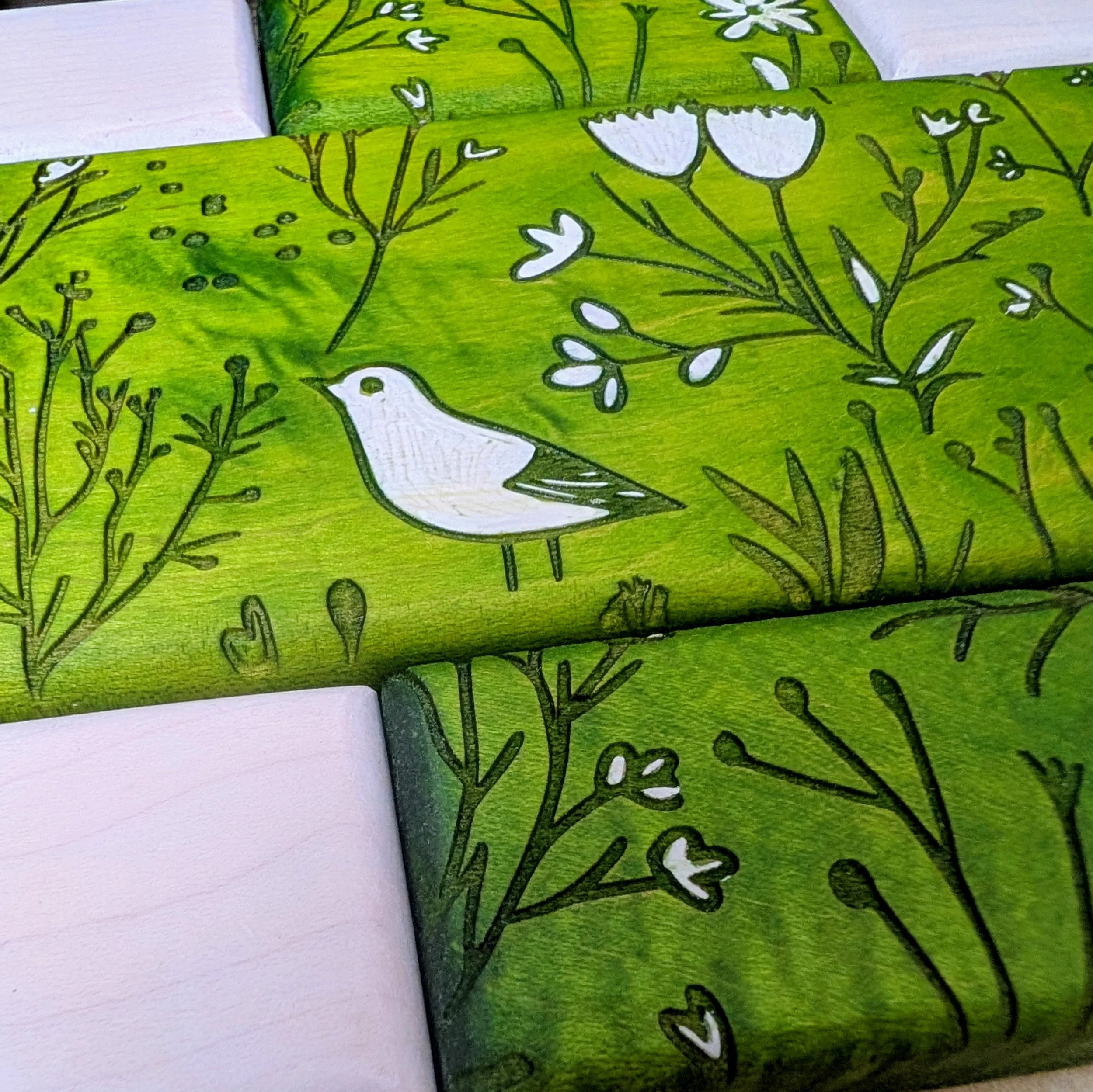 Green and white patterned wooden puzzle featuring bird and floral designs