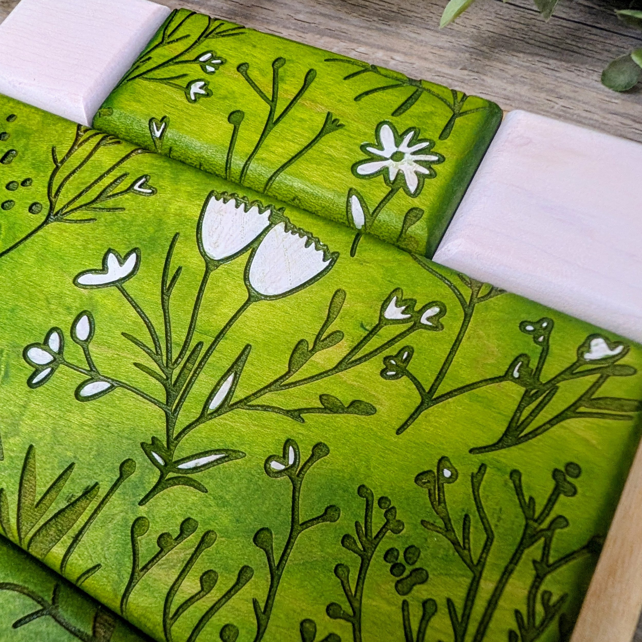 Green and white patterned wooden puzzle featuring bird and floral designs