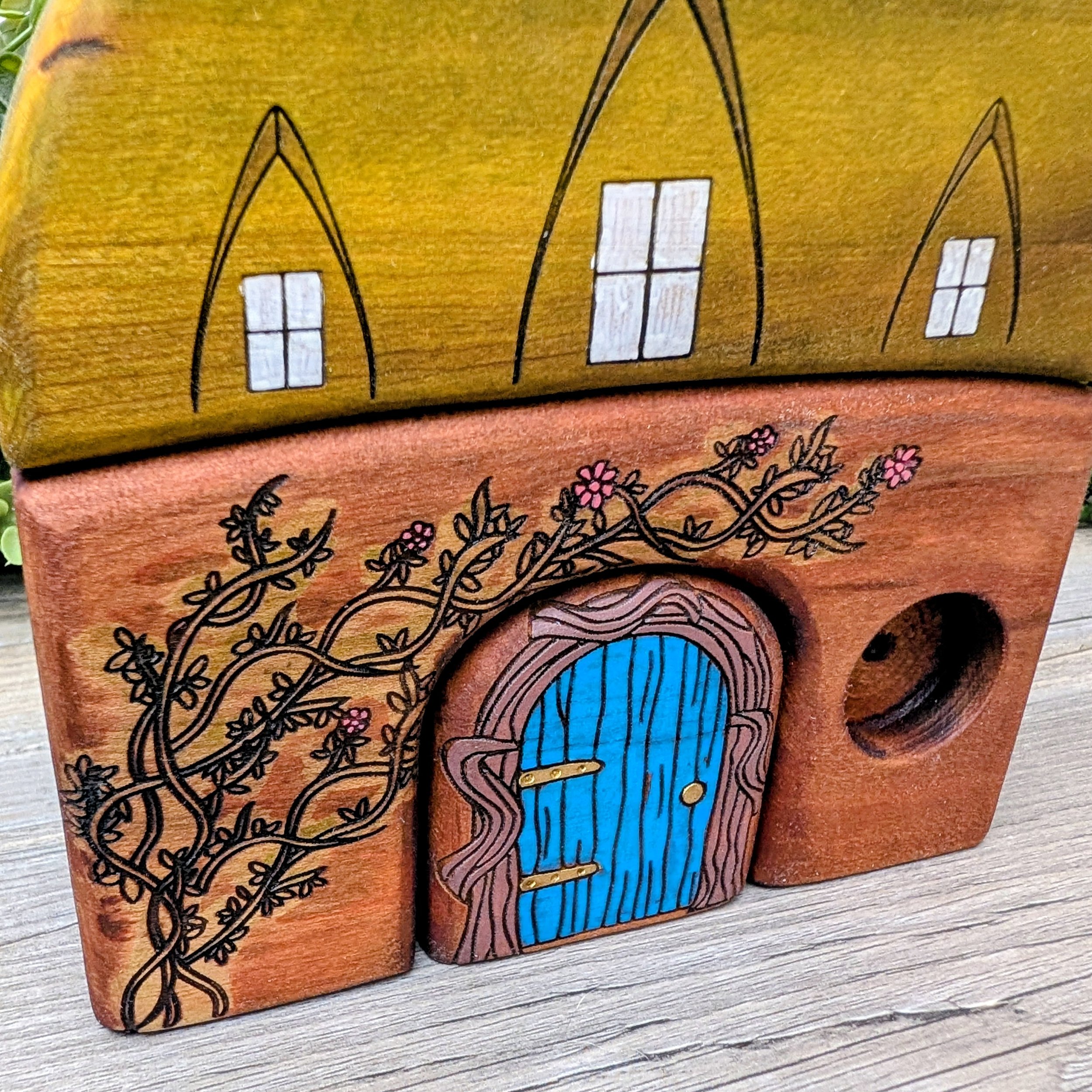 Forest-inspired wooden cottage toy with vibrant blue door