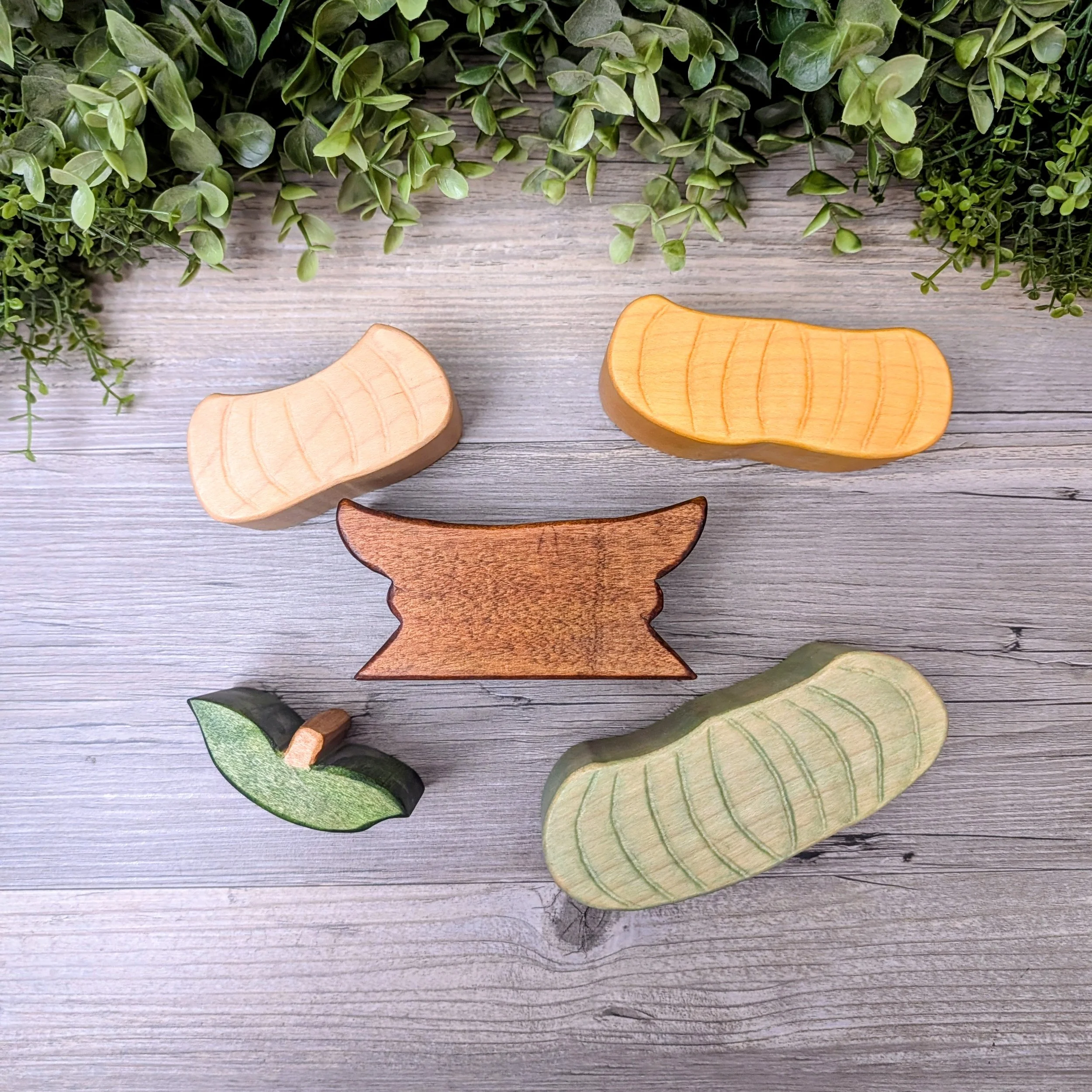 Pastel wooden pumpkins stacked on a brown base with a pumpkin topper