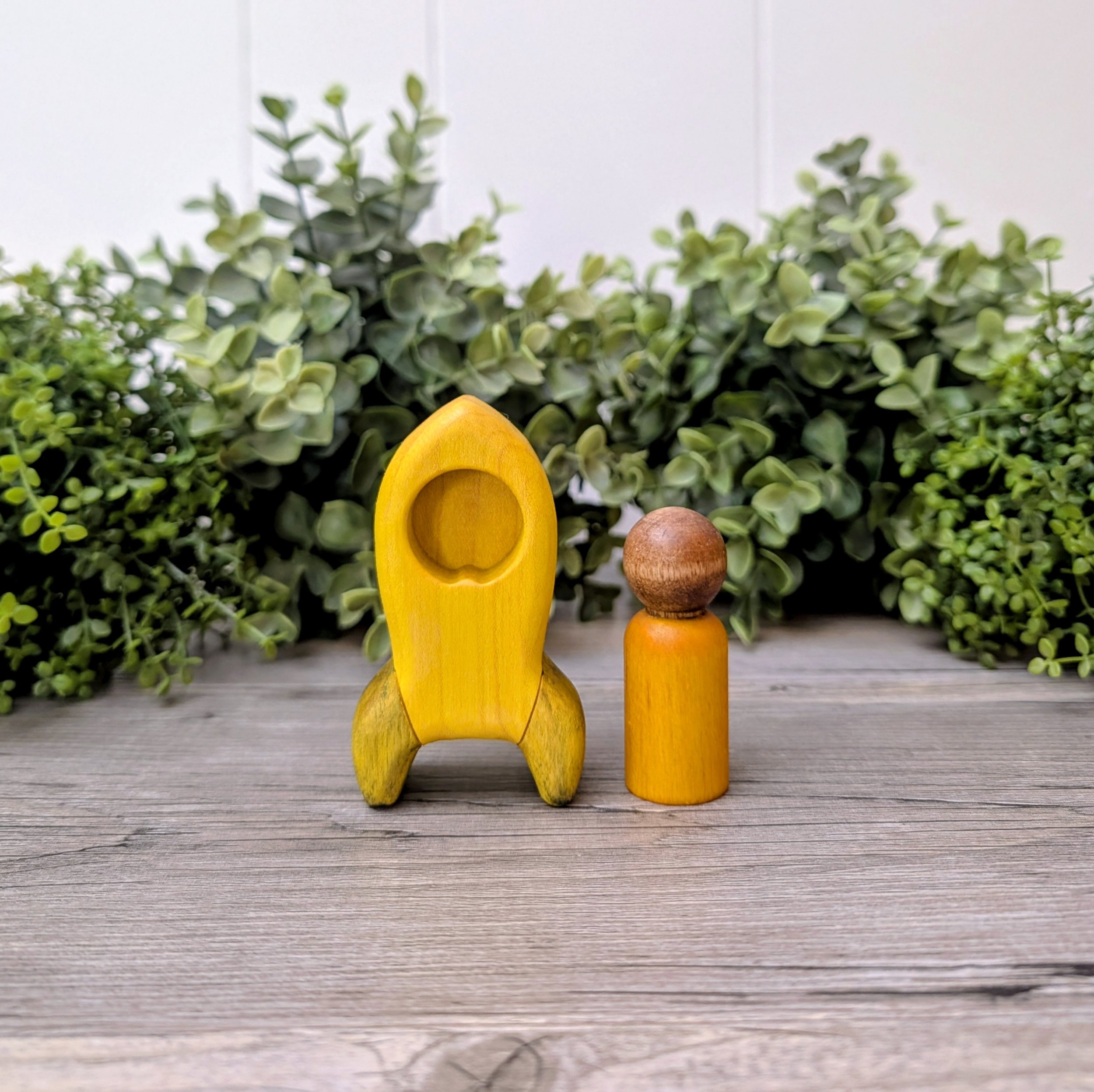 Wooden rocket ship toy with matching maple peg person