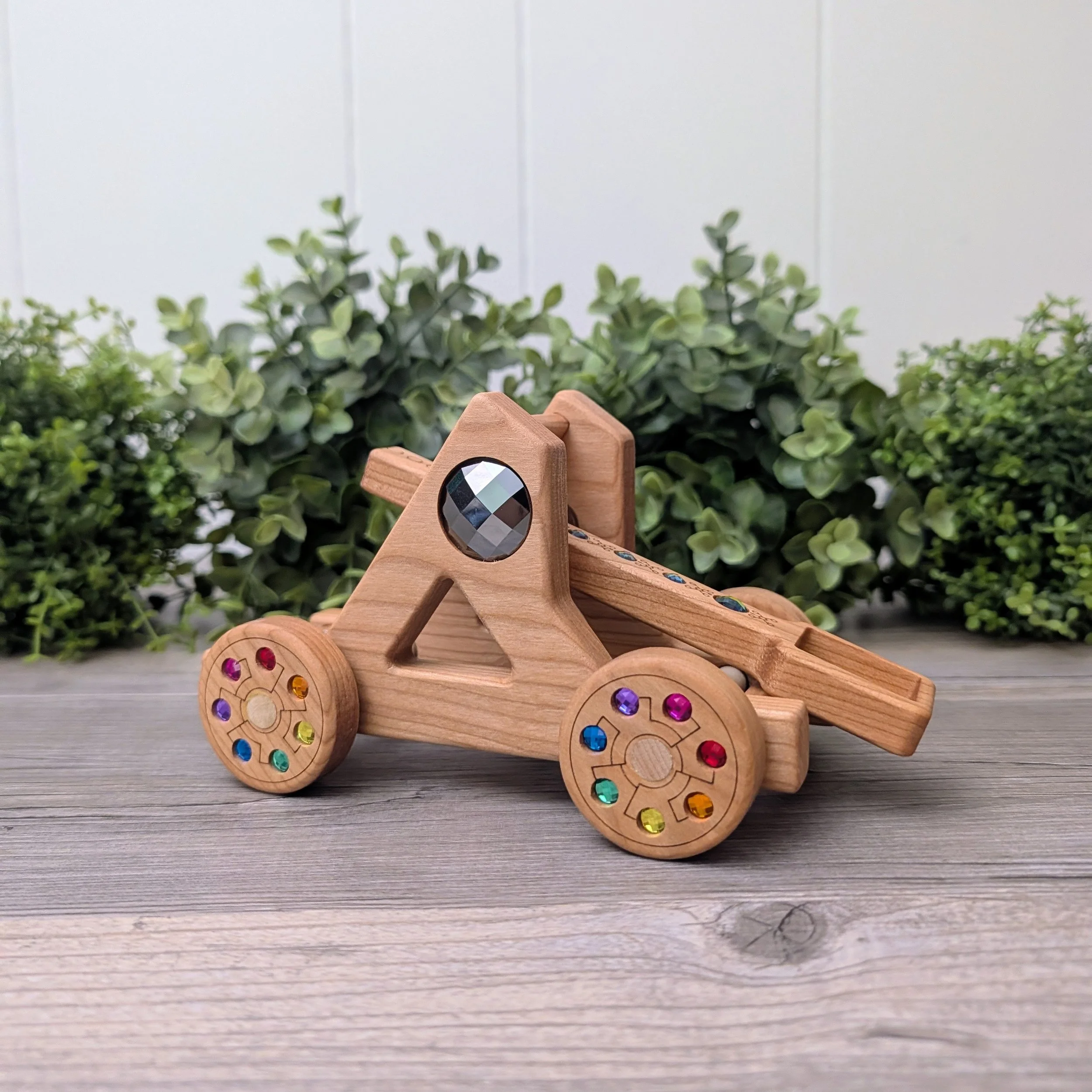 Cherry wood catapult with inset rainbow gems for imaginative play