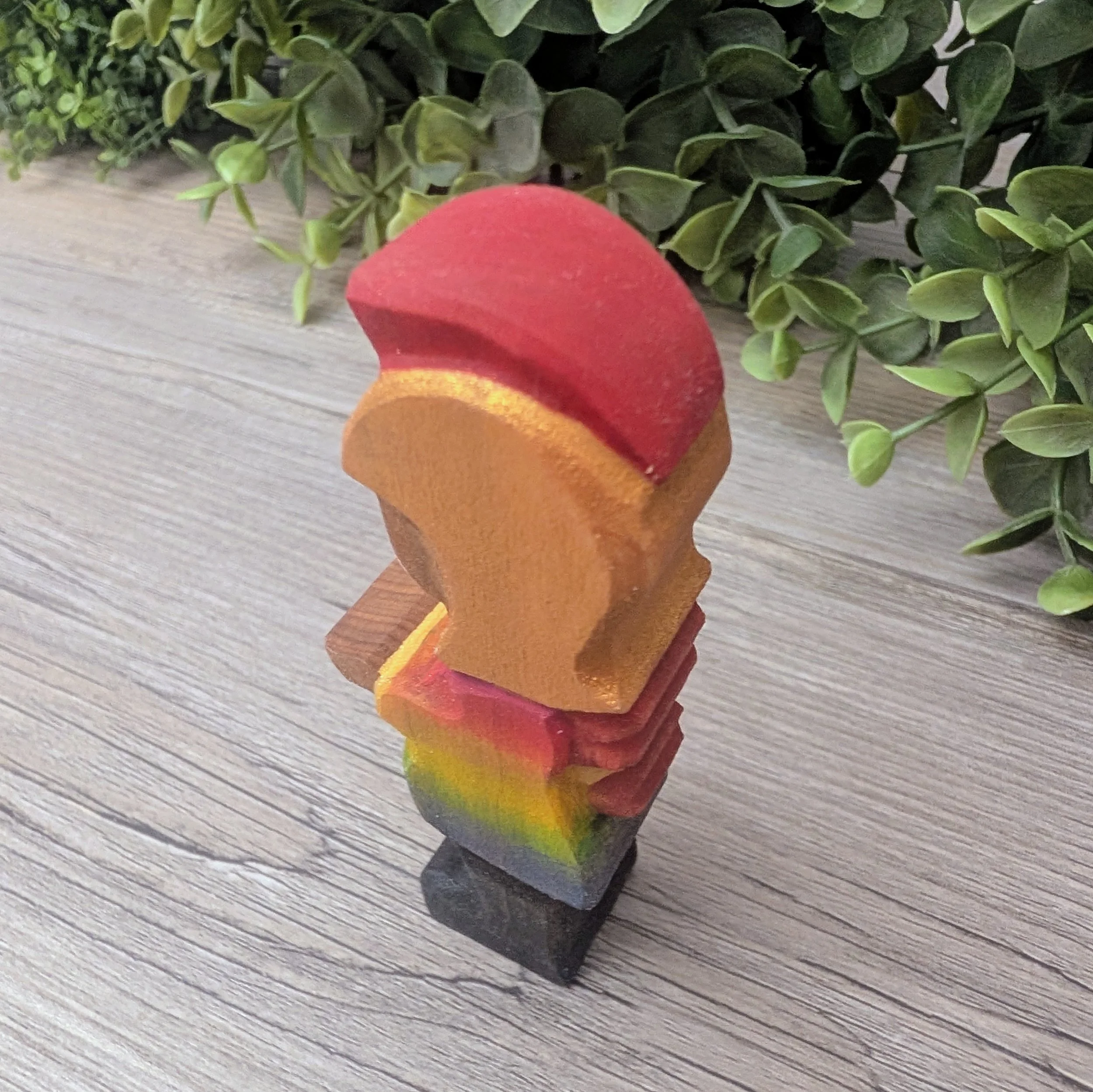 Hand carved wooden knight featuring a rainbow painted tunic
