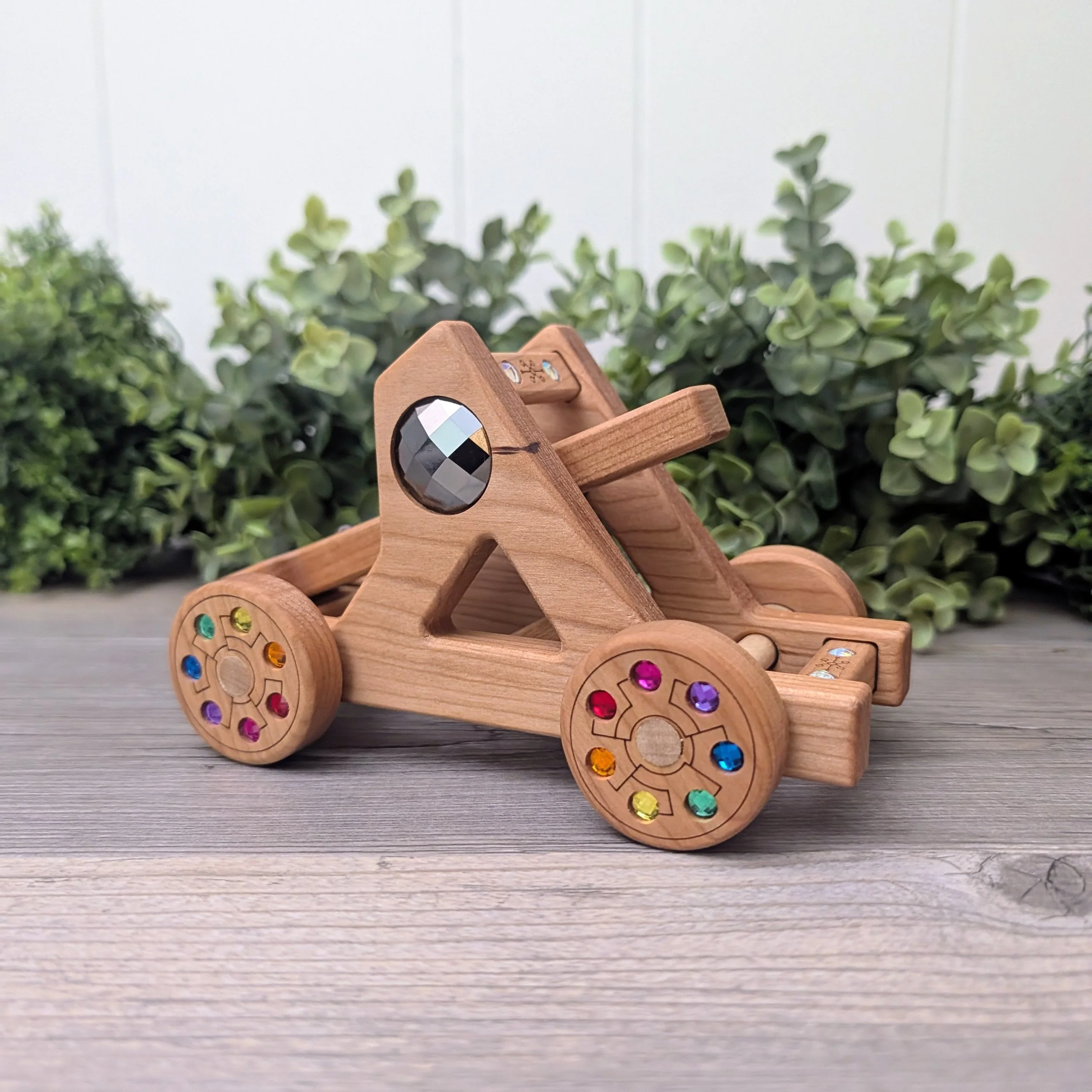 Cherry wood catapult with inset rainbow gems for imaginative play