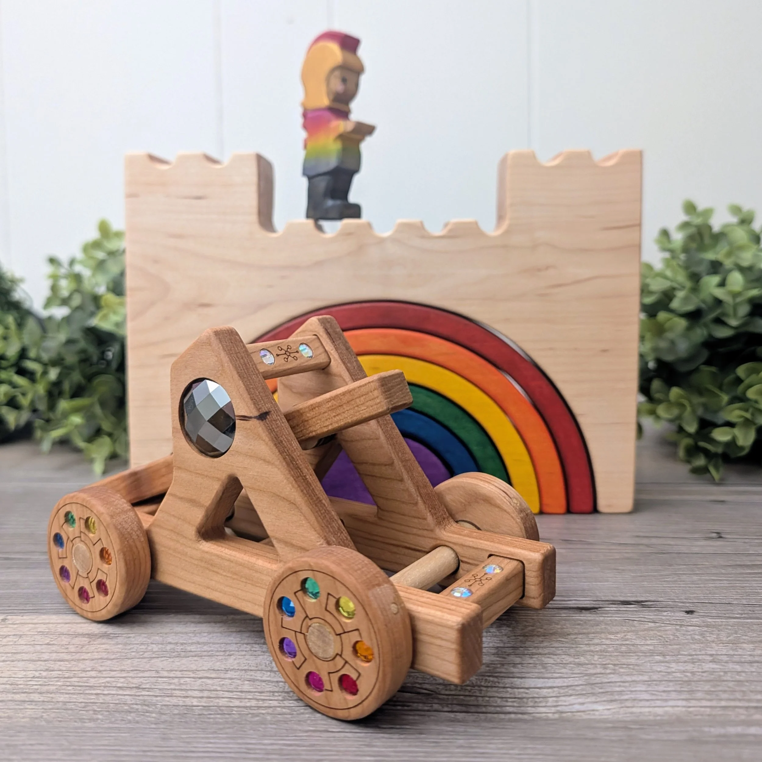 Three handmade wooden fantasy toys created by independent makers for the Rainbow Kingdom Collection