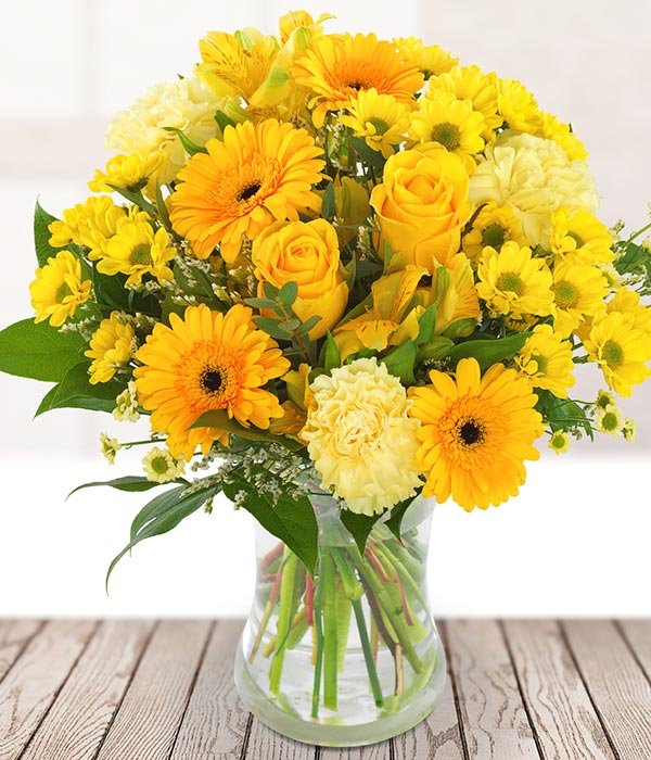 Bright and cheerful yellow flowers paired with a flash of green, tied into a bouquet.