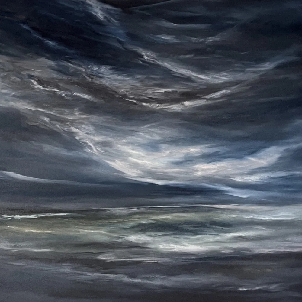 Stormy sky with dark, swirling clouds over a body of water.