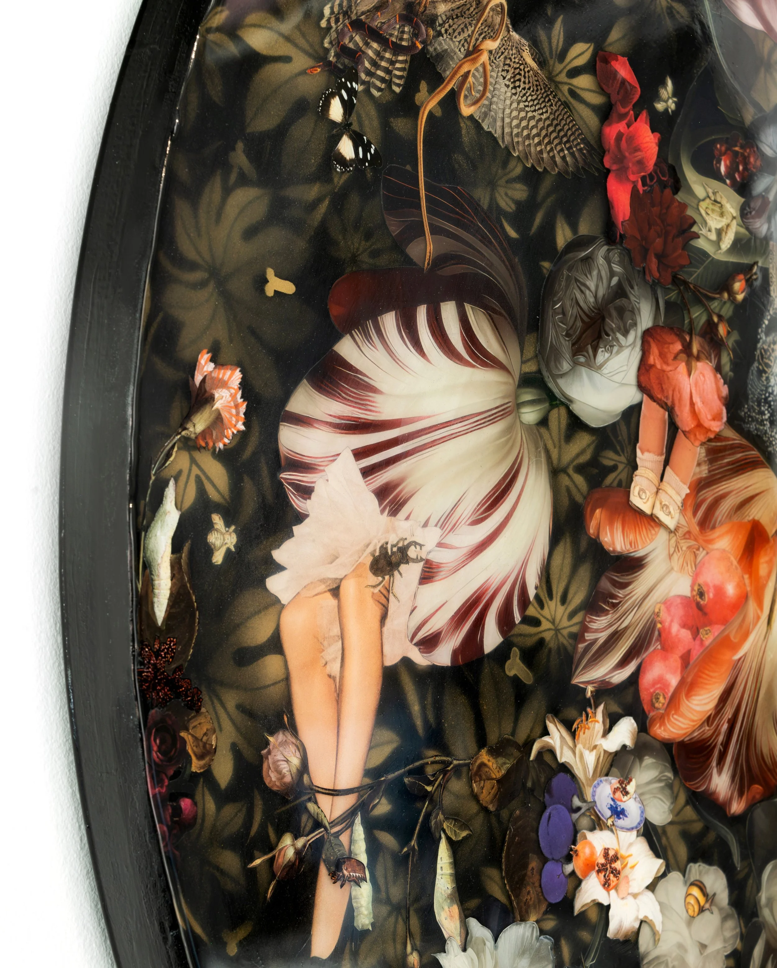 A glass art piece depicting a fairy with long hair, wearing a striped dress and lying among flowers, leaves, butterflies, and insects in a natural setting.