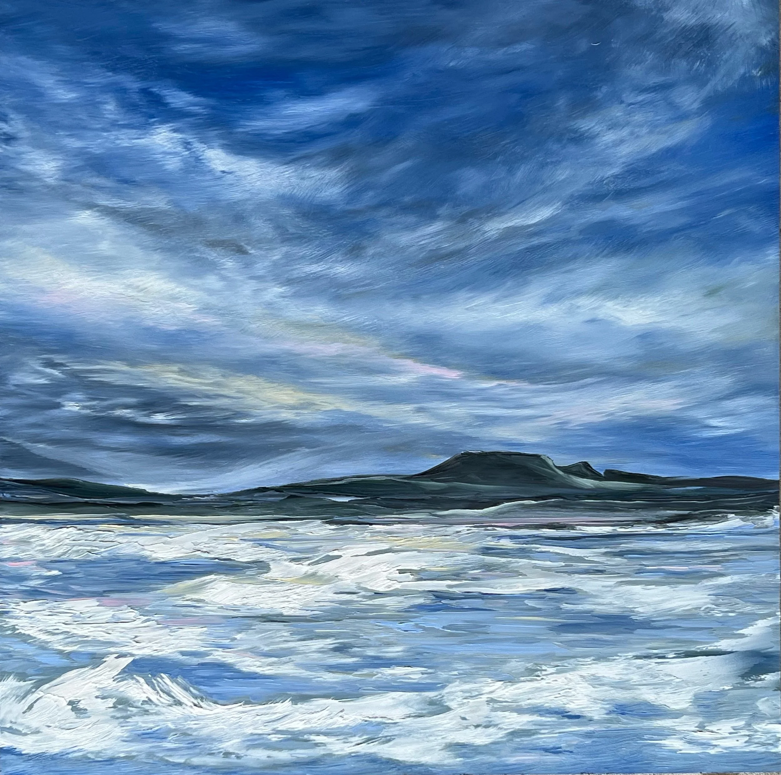 A vast expanse of ocean water with a deep blue hue, showing gentle waves and ripples under a cloudy sky.