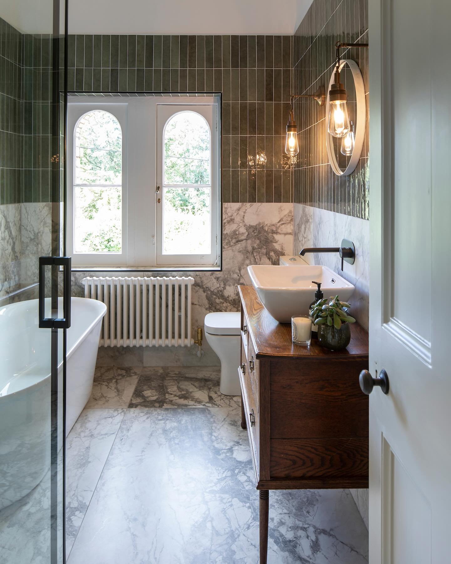 A bathroom which was influenced by the view through the original arched windows. We combined antique furniture with contemporary finishes to find a balance between retaining the character of the Victorian Villa and injecting the clients own personali