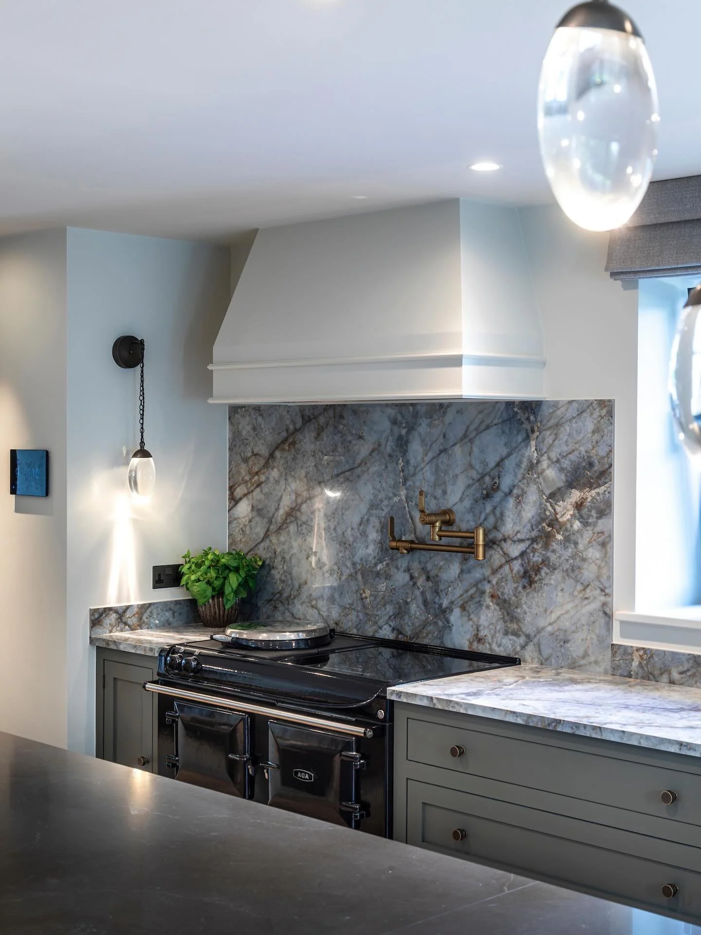 This beautifully crafted kitchen takes inspiration from the natural landscape surrounding Lake Windermere.  The design embraces a soft, earthy palette &mdash; from the veined stone surfaces to the muted cabinetry &mdash; reflecting the colours of the