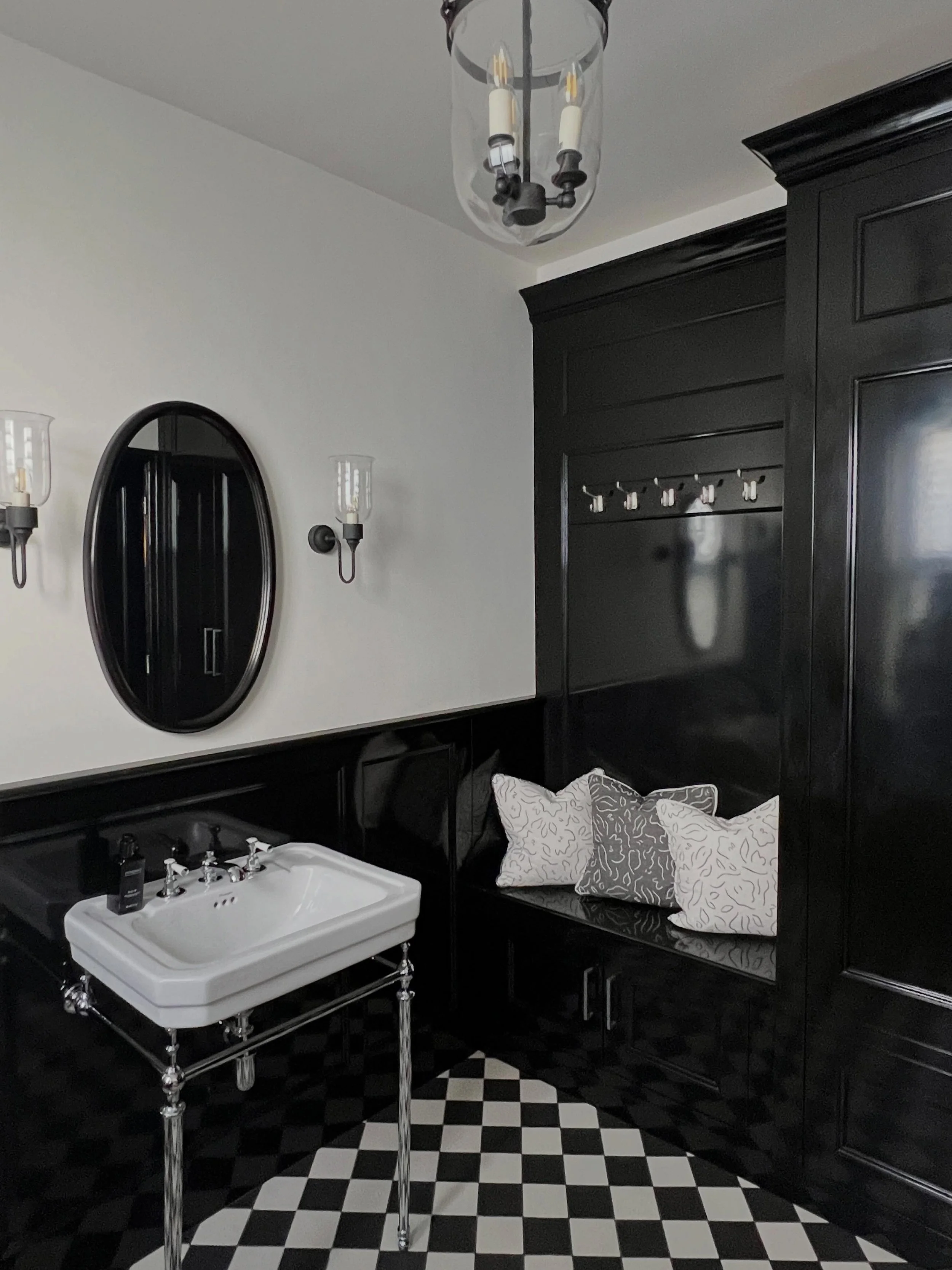 The existing checkerboard floor became the starting point for this monochrome powder room 🖤
Rather than compete with it, we allowed the space to evolve from there - adding high-gloss black panelling and cabinetry, to create something that feels both