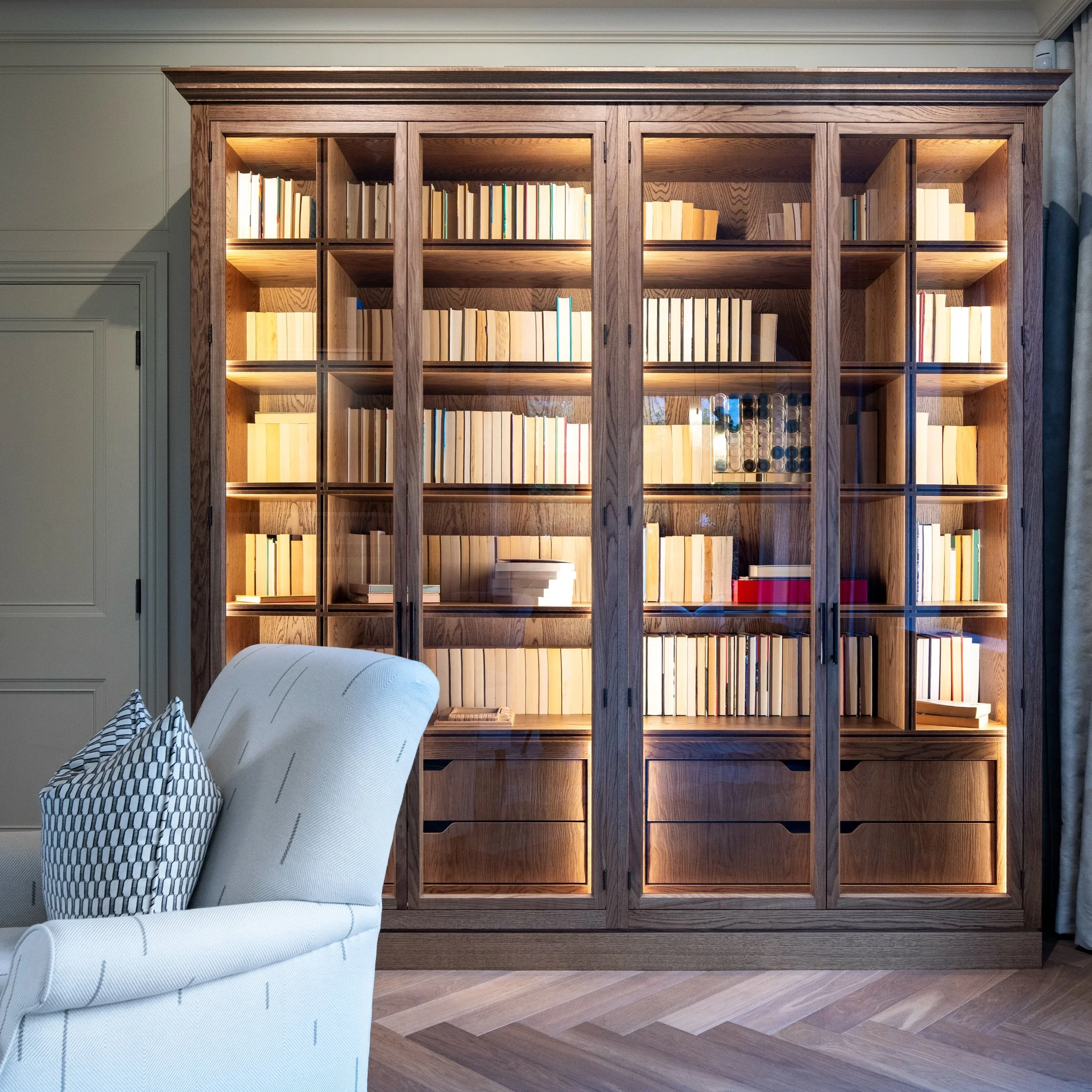 Designed to provide generous storage for our clients&rsquo; collection of books and games, this bespoke library cabinet combines open shelving with concealed drawers below, keeping everything close at hand while creating a striking piece of furniture