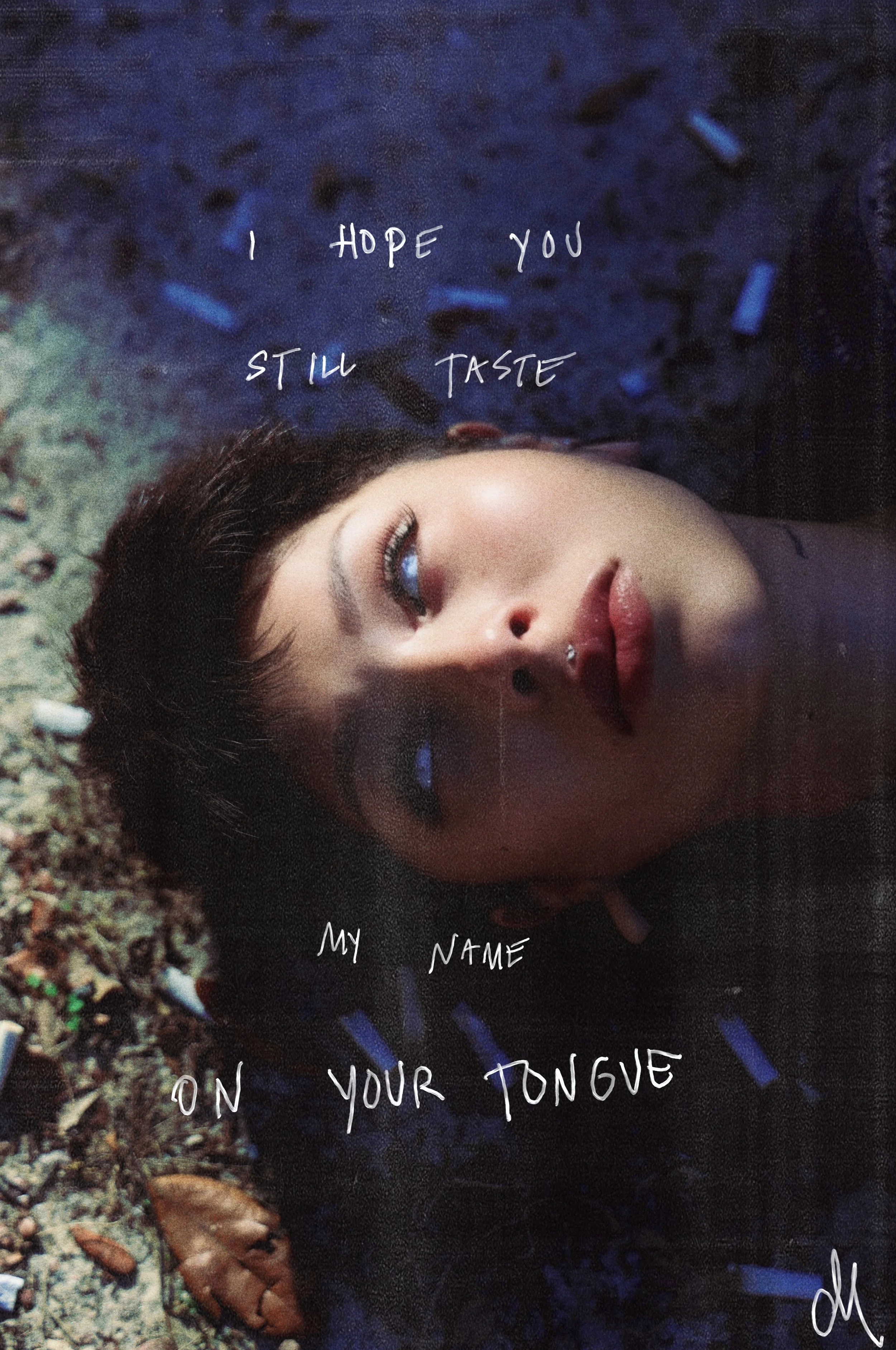 A woman with makeup lying on her back on the ground with debris, with handwritten text reading "I hope you still taste my name on your tongue."