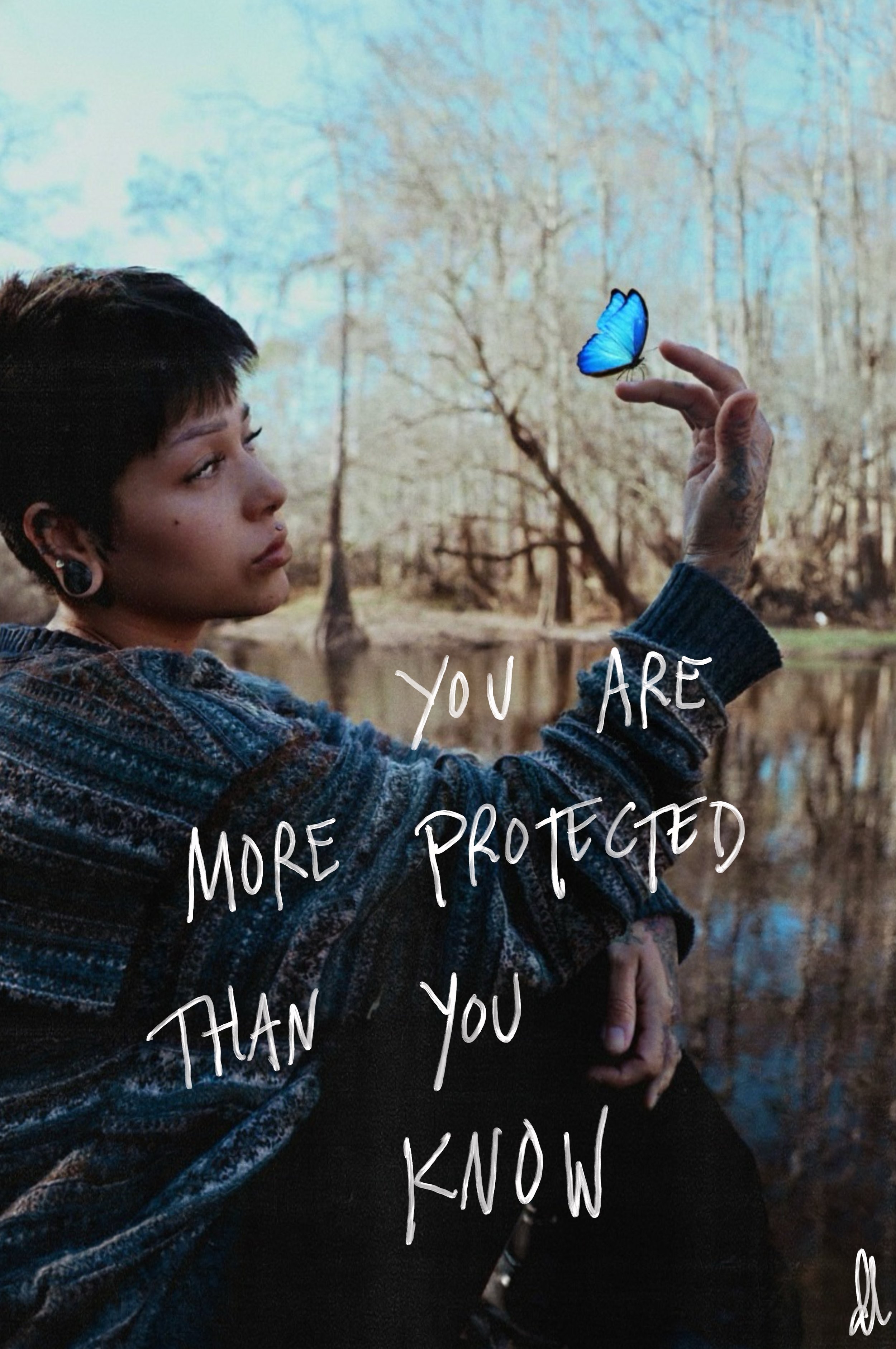 A young person with short dark hair and earrings, sitting outdoors by a body of water with trees in the background, holding a blue butterfly on their finger. Overlaid text reads, 'You are more protected than you know'.