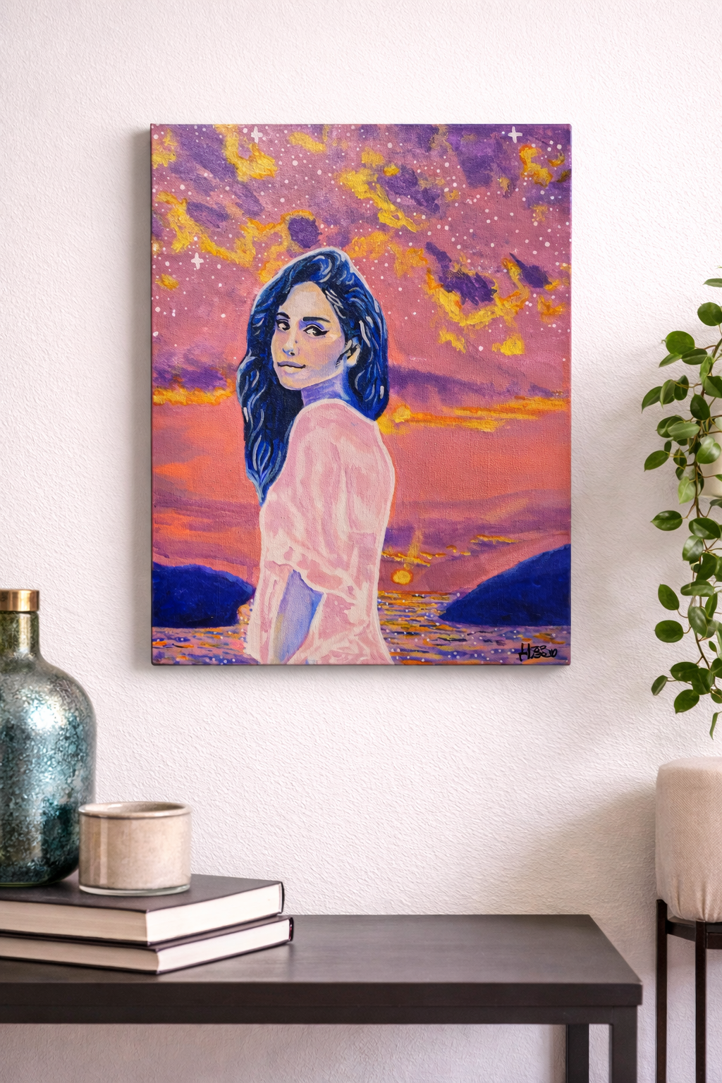 Close-up of a string of colorful beads on moss. The beads are shiny with reflections, mainly in blue, with some in peach and gold hues.