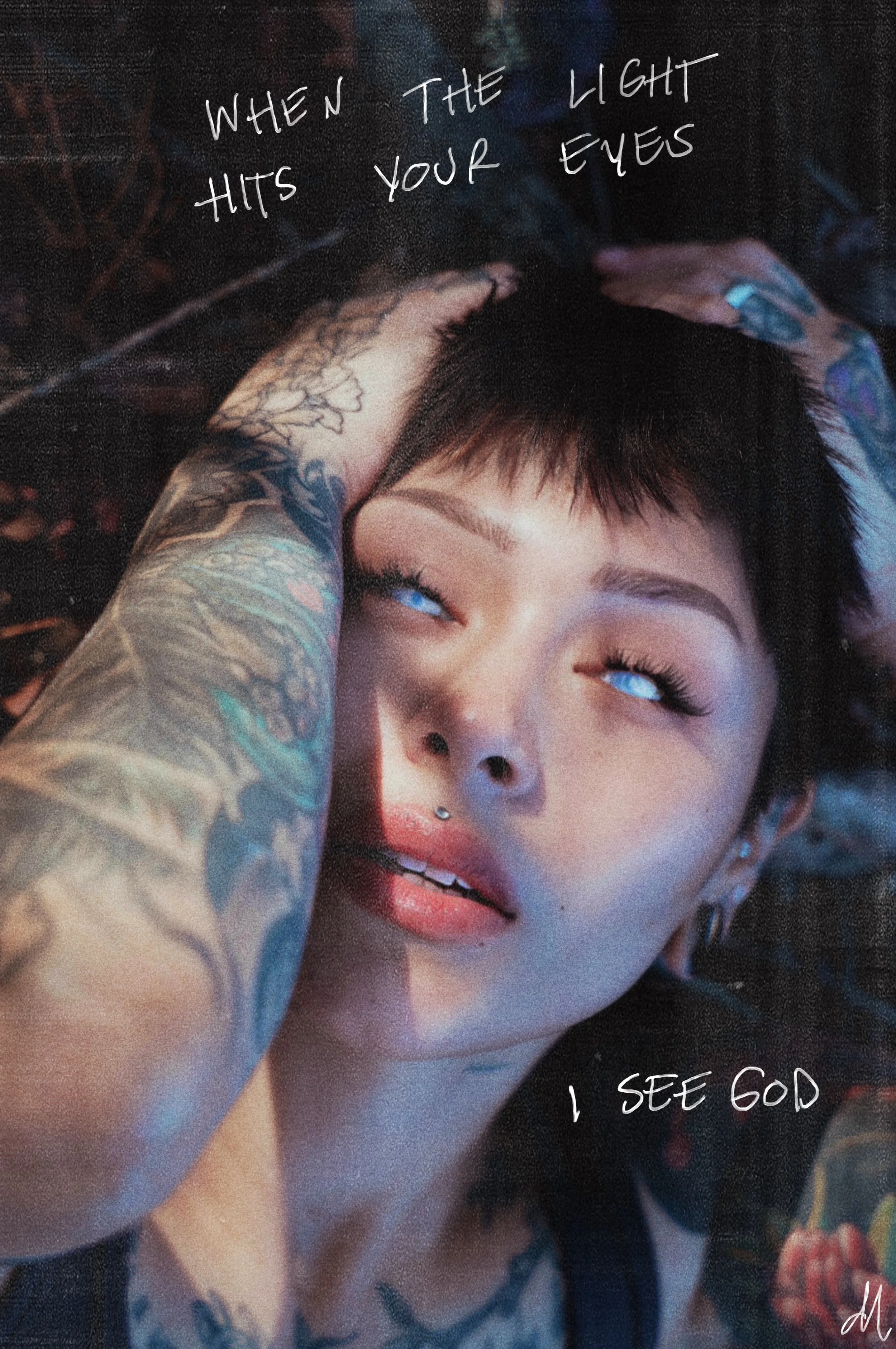 A young woman with tattoos and piercings lying on the ground with her eyes rolled back, her mouth slightly open, and her hand on her head. Handwritten text overlaying the image reads 'When the light hits your eyes' and 'I see God.'