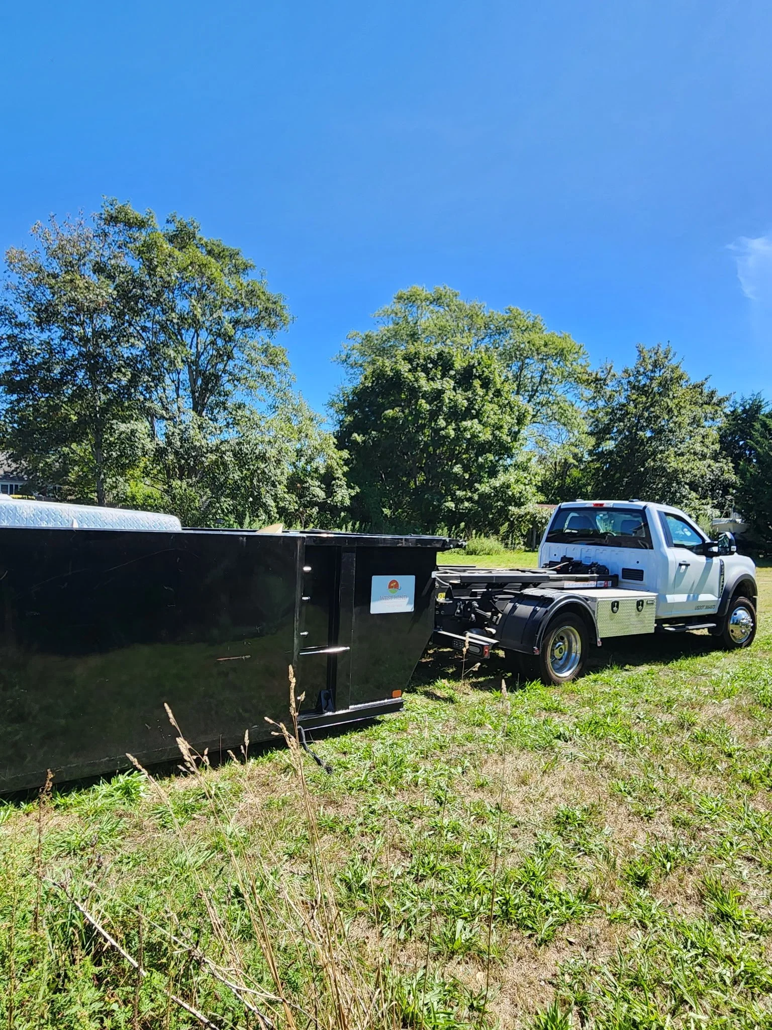 White roll-off dump truck used for dumpster rentals and dump runs, providing fast debris removal and property cleanouts