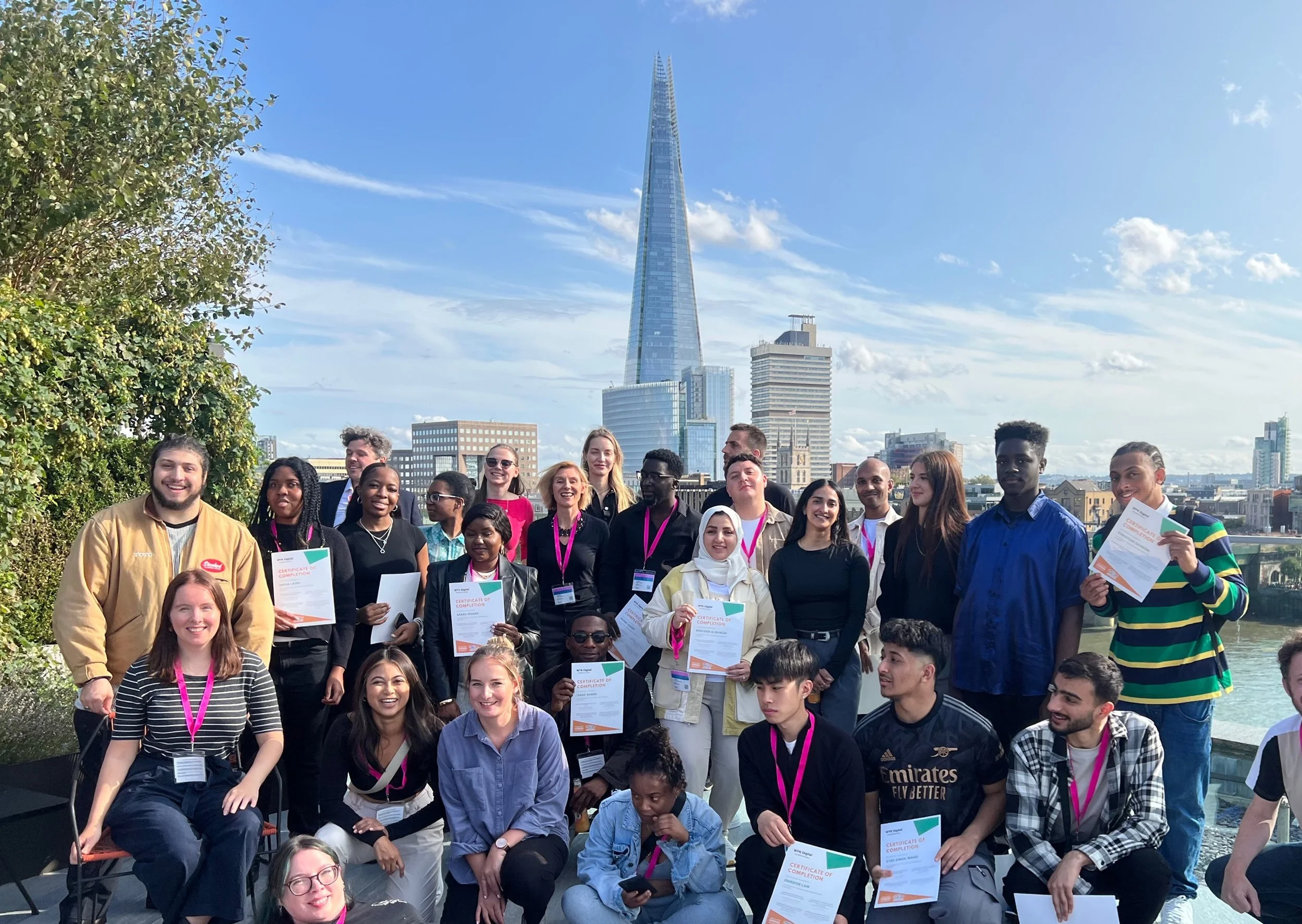 Group of WYK Digital students with their certificates after graduating on roof top with the Shard in the background