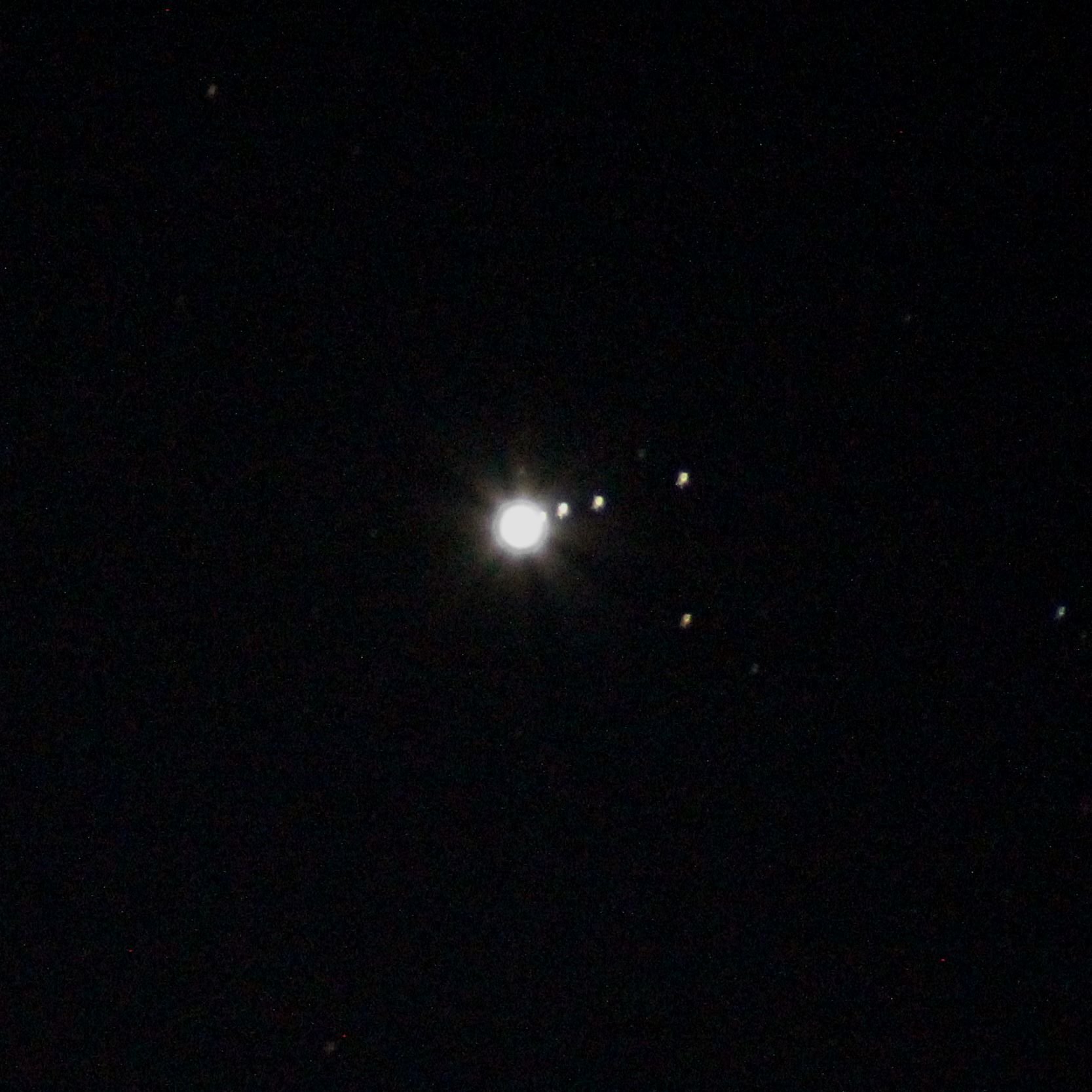 The moons of Jupiter. The planet has to be overexposed to see the dimmer moons. The trailing is from either movement of the camera or the Earth.