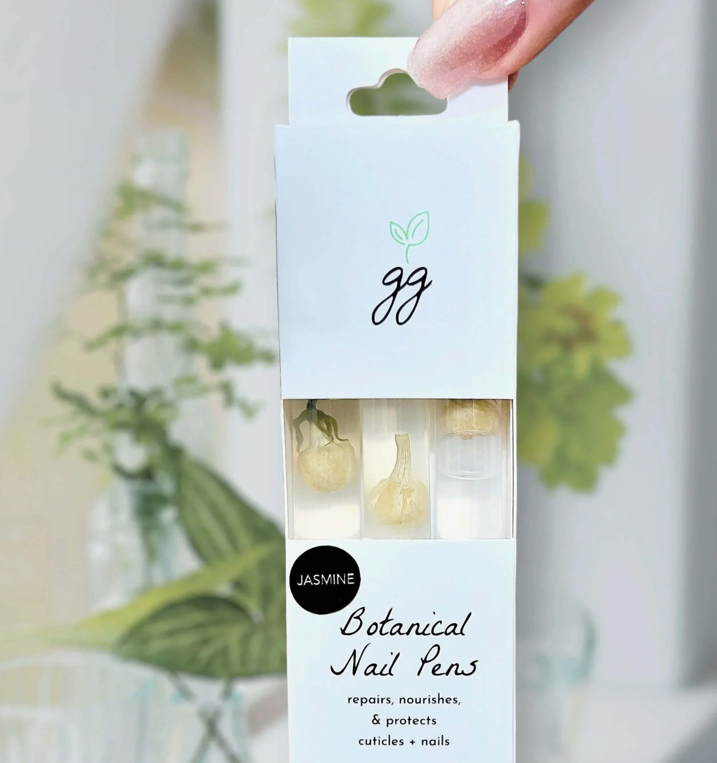 Boxed Jasmine cuticle oil pen 3-pack by Greenmade goods in front of a houseplant