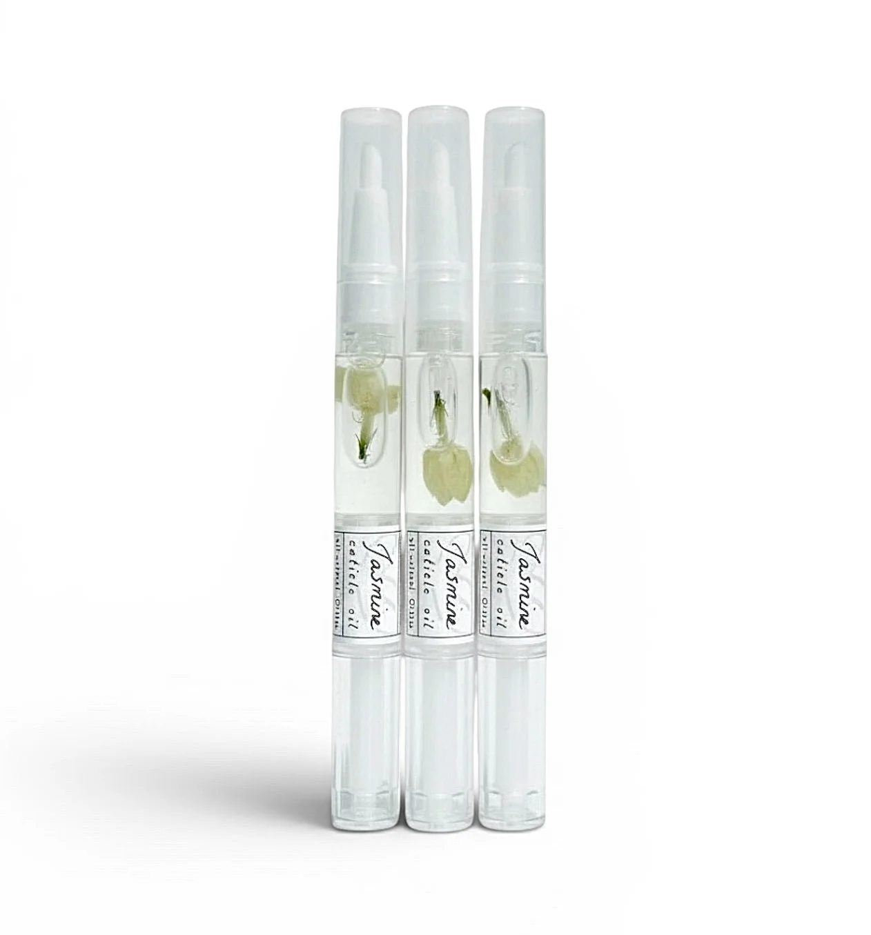 Three Jasmine cuticle oil pens by Greenmade goods with real jasmine flowers inside