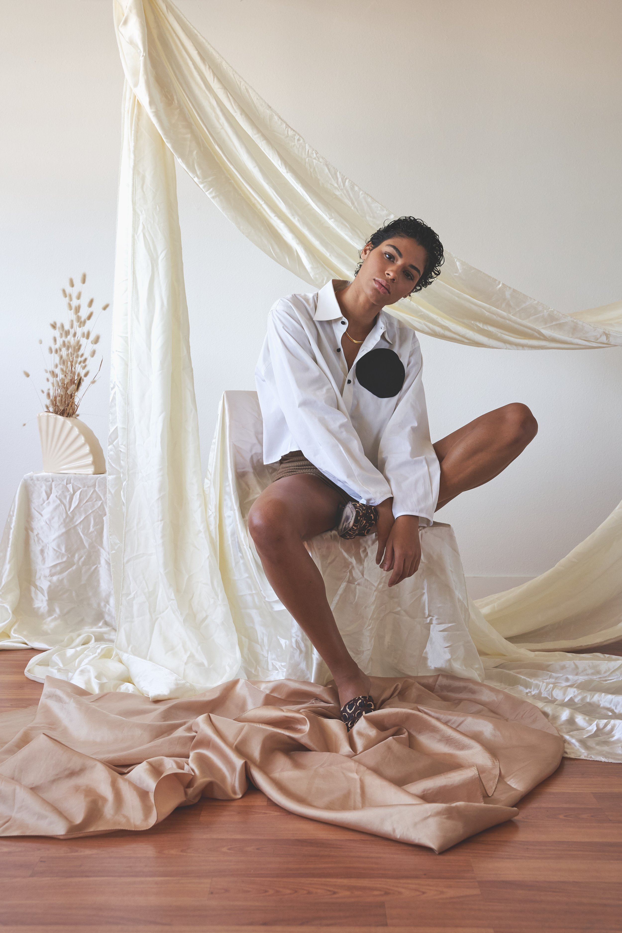 cropped white button-up shirt with a round black pocket on a model