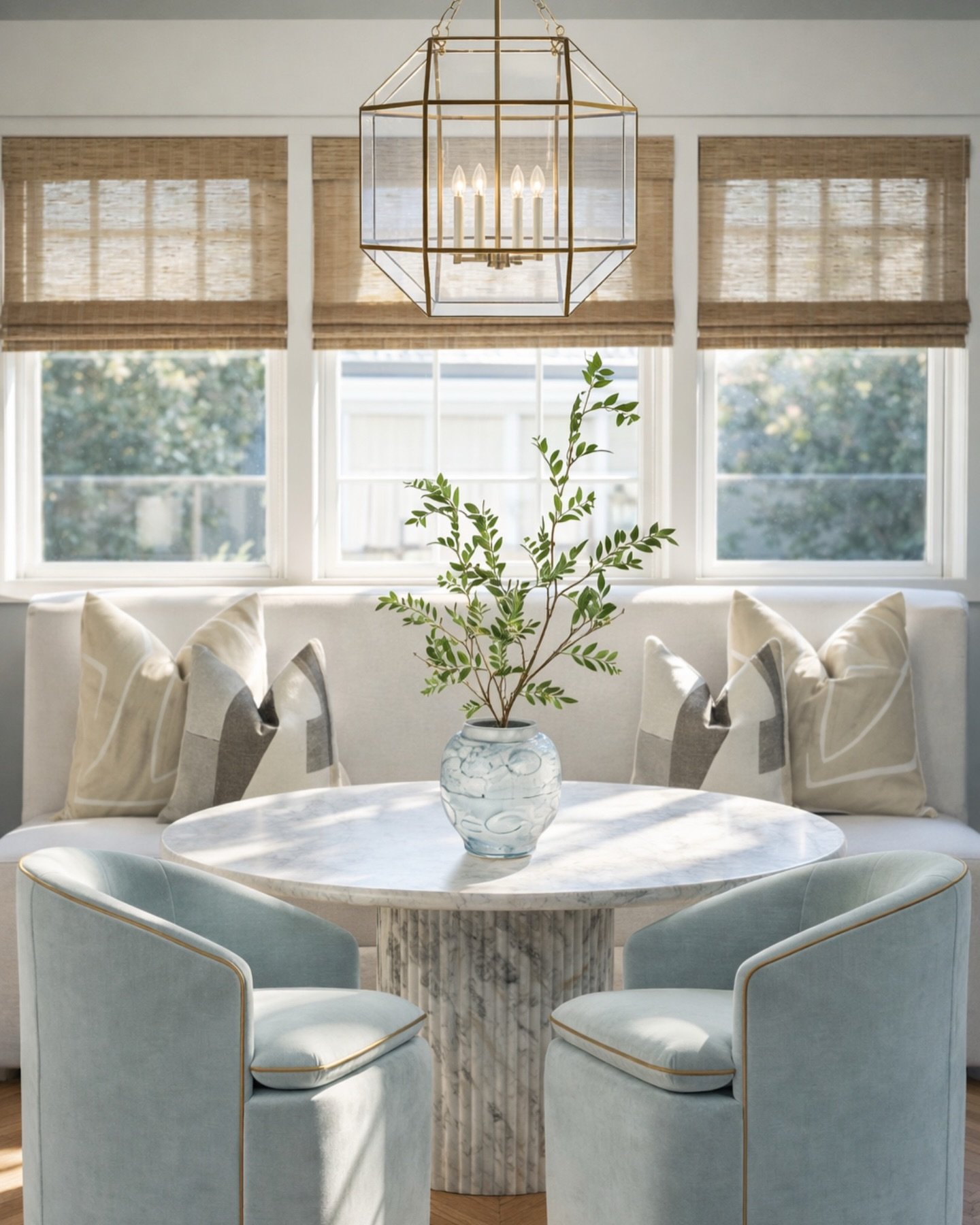 This is how you make a breakfast nook feel expensive without trying too hard.

The mix here is everything&mdash;soft blue velvet, warm brass, and that sculptural marble base all layered against natural light and woven textures. It feels elevated but 
