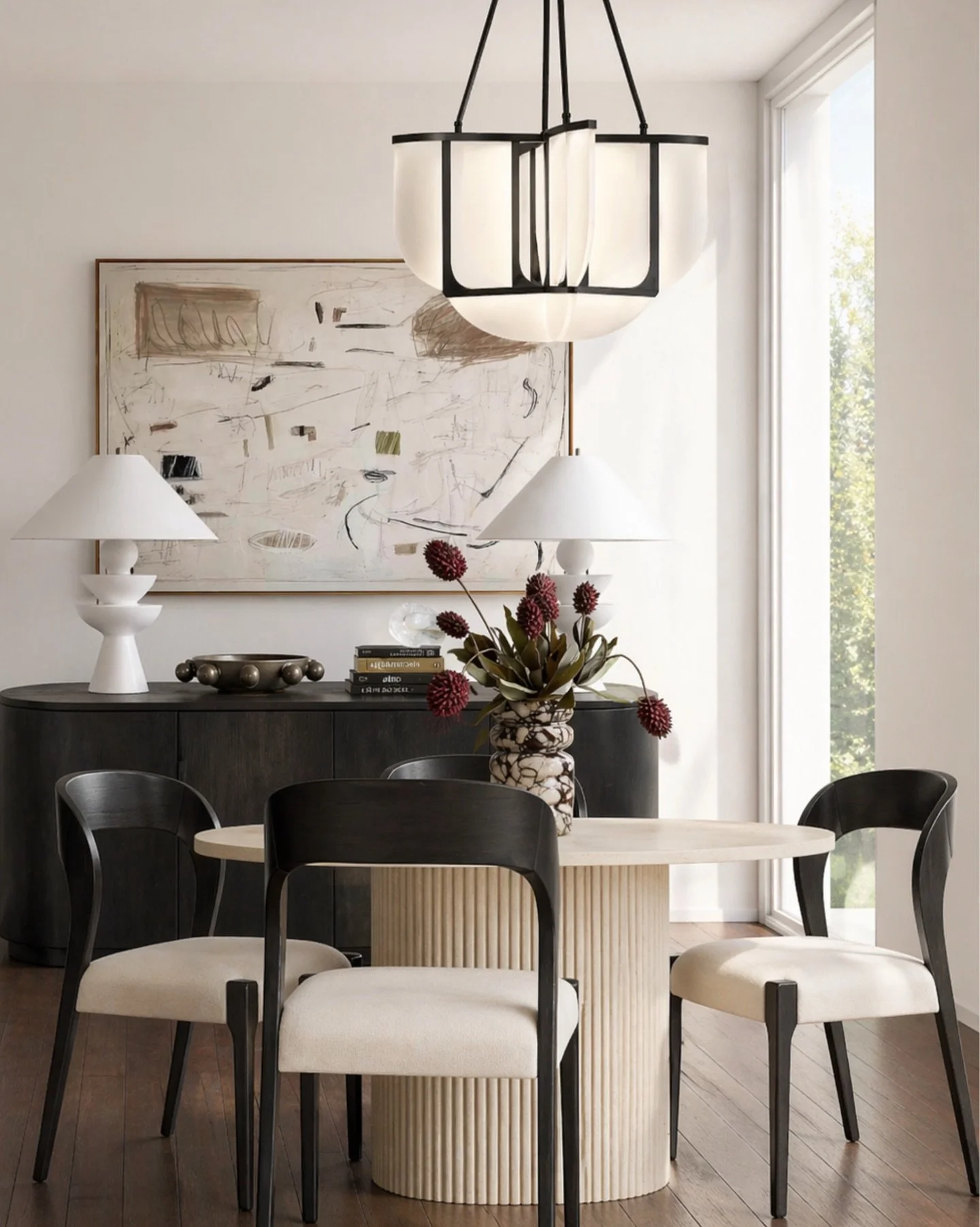 This is the kind of dining setup that makes everything feel intentional without trying too hard.

The mix of soft neutrals and black contrast keeps it grounded, while the sculptural base and curved chairs add just enough interest to make it feel elev