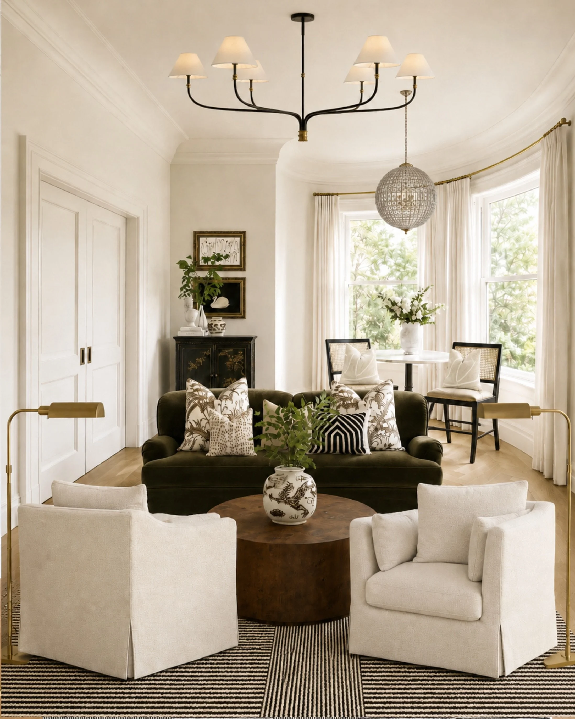 A room that feels collected, layered, and polished without trying too hard.

The mix of skirted chairs, a dark velvet sofa, warm wood, black accents, brass lighting, and patterned pillows gives this space that classic-but-interesting look I always co
