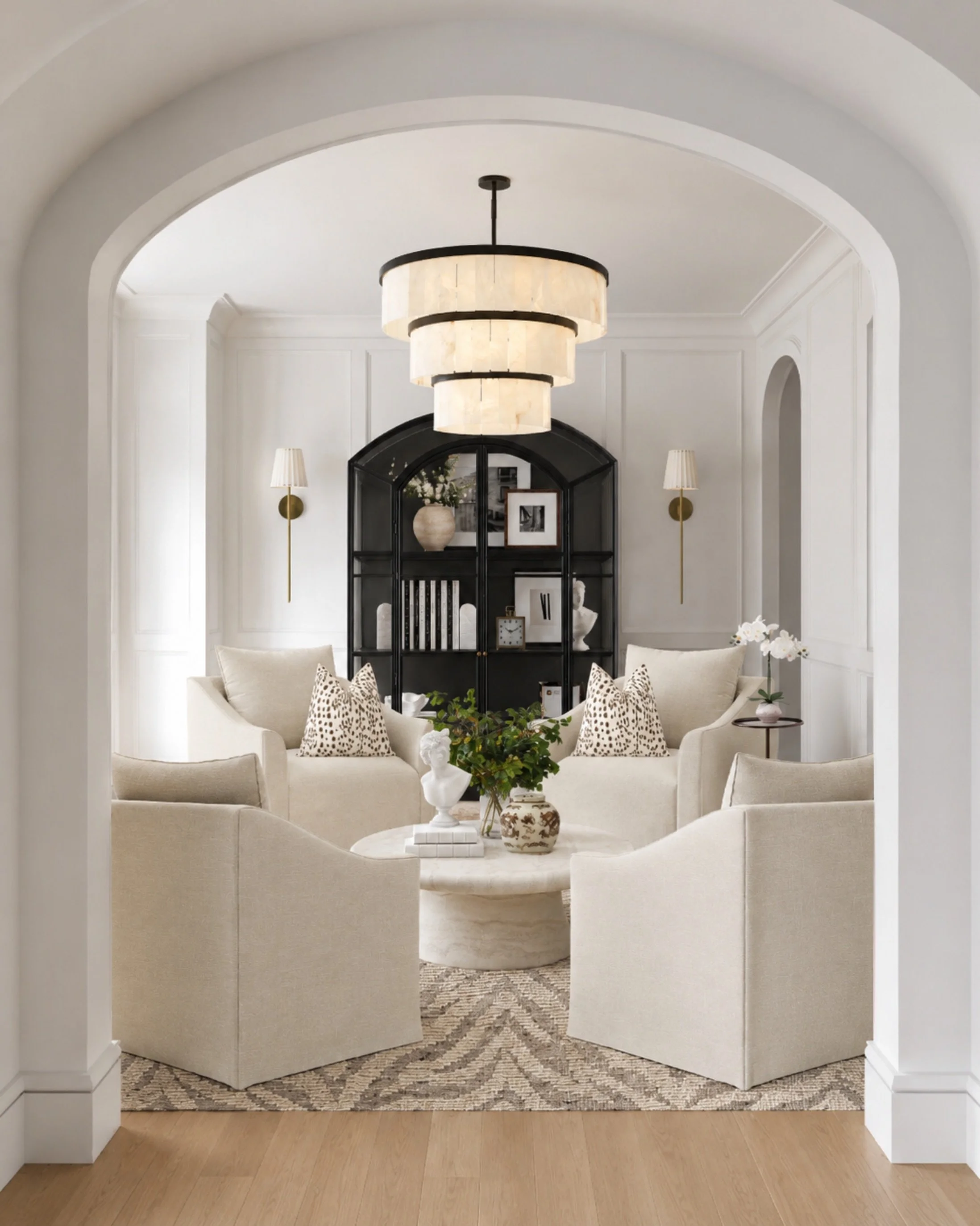 Soft neutrals, sculptural pieces, and a little contrast for the perfect collected living room moment 🤍

I love how the black arched cabinet grounds the space while the cream chairs, marble coffee table, layered lighting, and patterned pillows keep e
