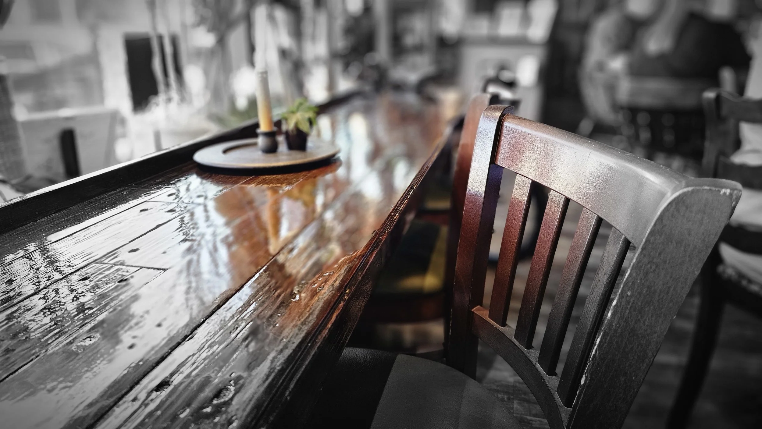 A polished wooden counter and chair inside Bourbon Cafe and Coffee Saloon in Bourbon, Missouri.