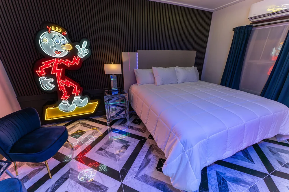 King bed and Reddy Kilowatt neon artwork in the Neon Room.