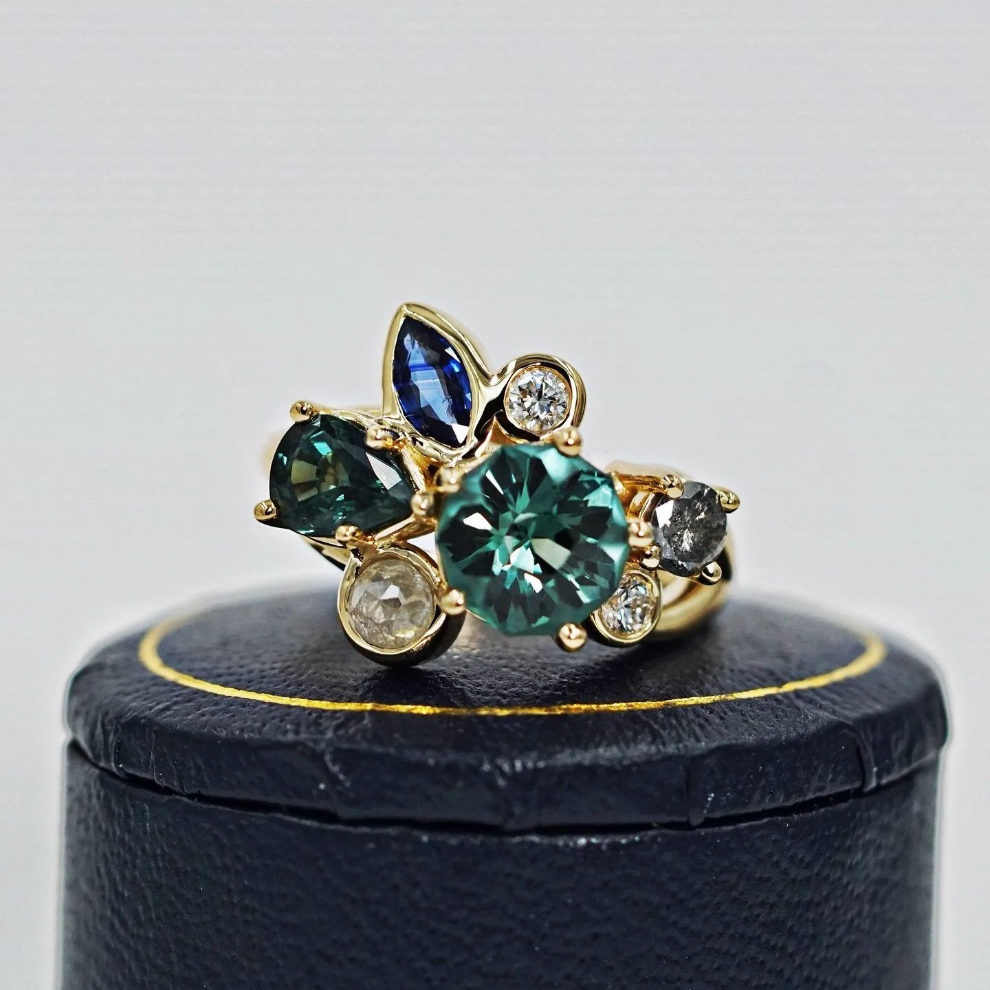 Dark & Stormy βοΈ Griffin’s Custom Engagement Ring Cluster in 18k Yellow Gold
When Kelsey first contacted me, she had a stunning custom-cut green sapphire and wanted to complement it with additional stones.
We had several studio sessions w