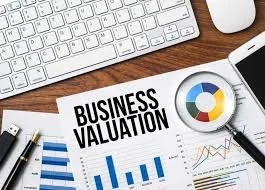 Business valuation document on wooden desk with keyboard, mouse, and pen
