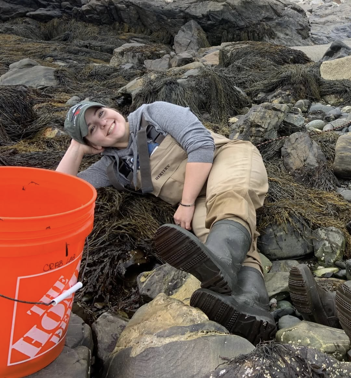 Aubrey laying on seaweed while tidepooling