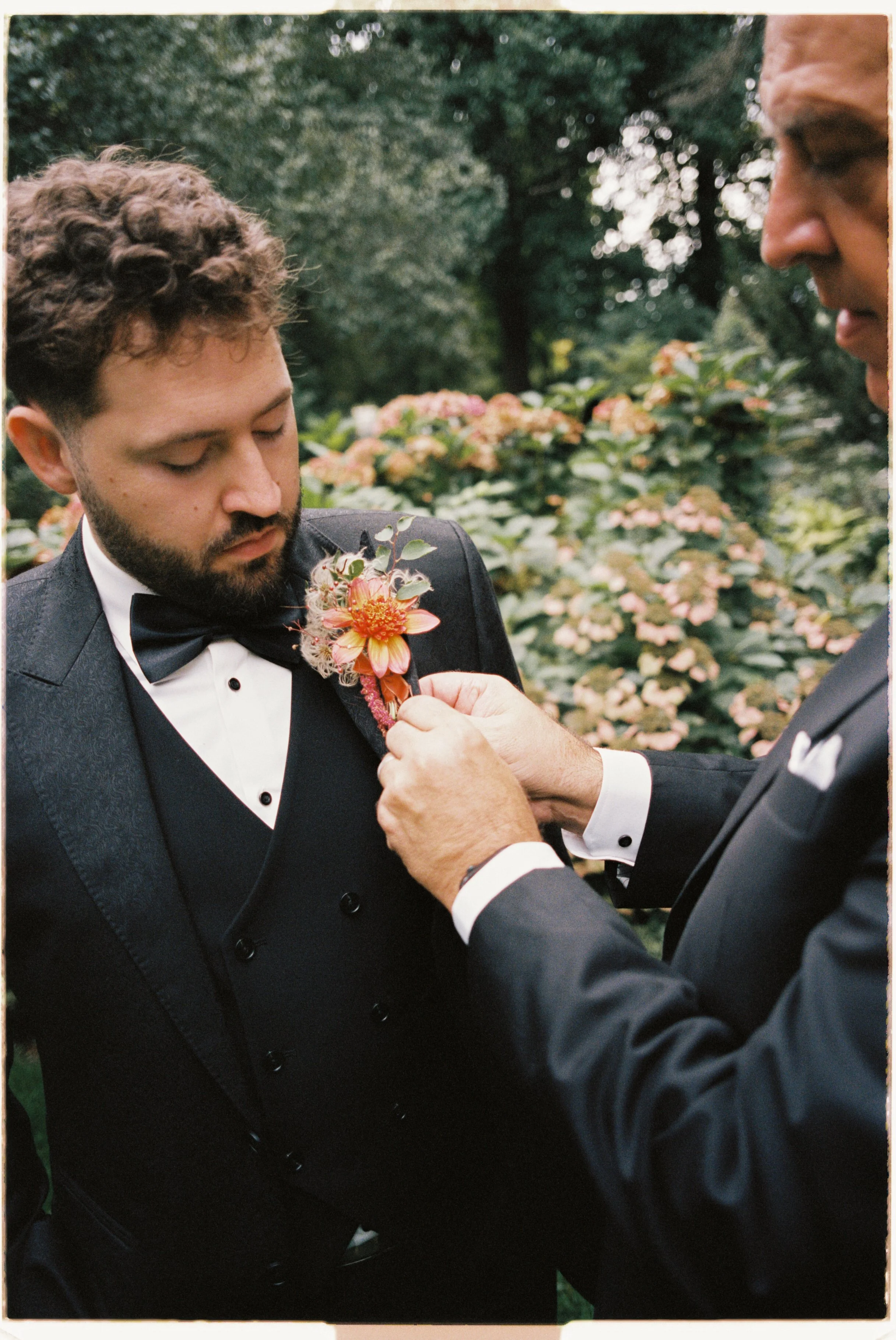 Bespoke Boutonniere featuring orange dahlias and fluffy greenery for the groom, designed by a wedding florist in Pickering