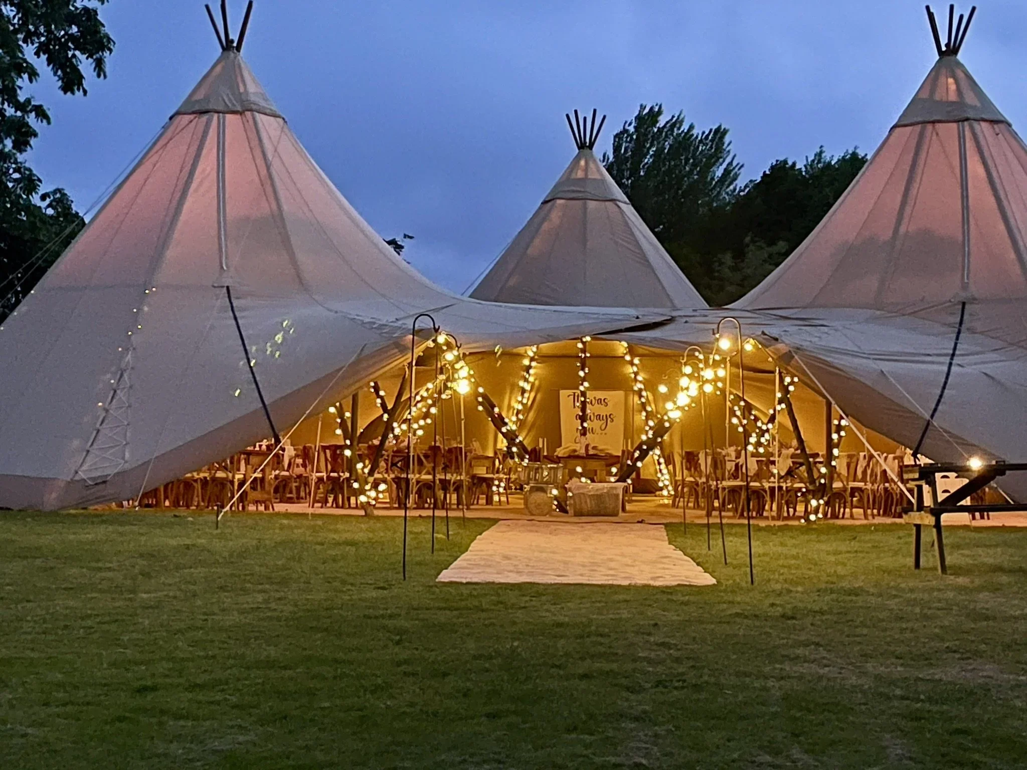 Picture of tipi tents with lights and an aisle
