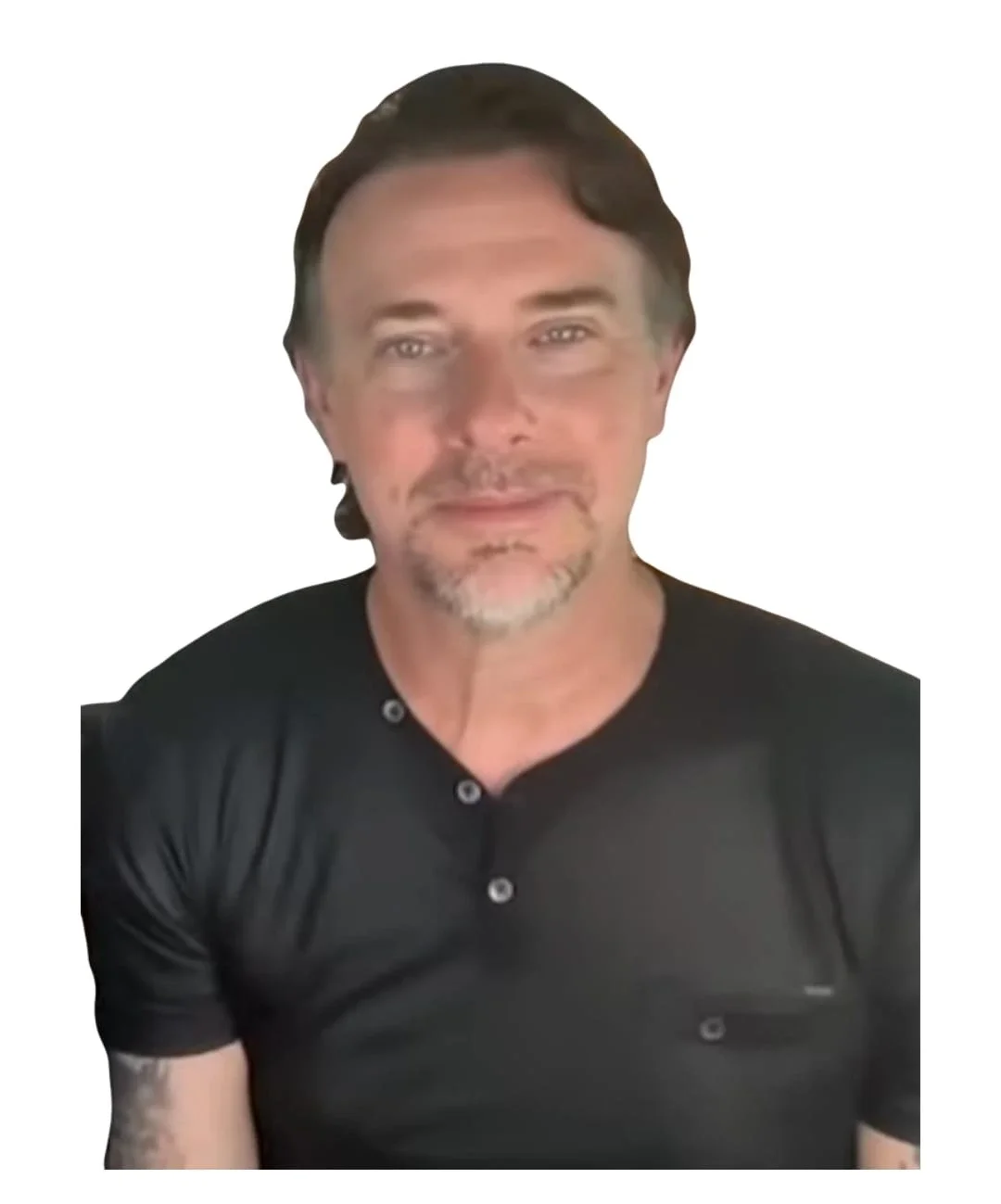 A man with brown hair, a goatee, and wearing a black shirt with buttons, sitting against a plain white background.