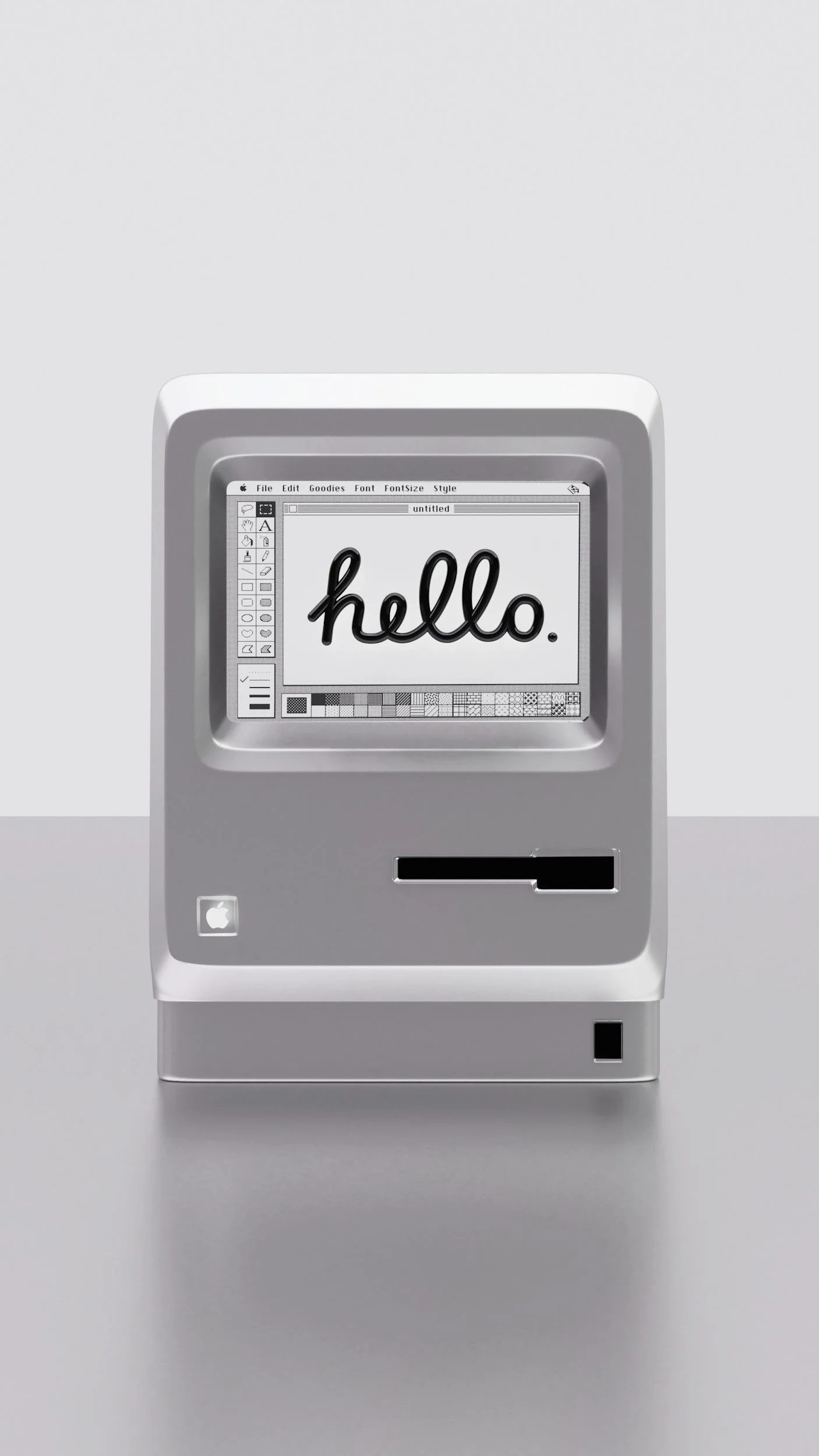 A vintage Apple Macintosh computer displaying a screen with the word 'hello.' written in cursive.