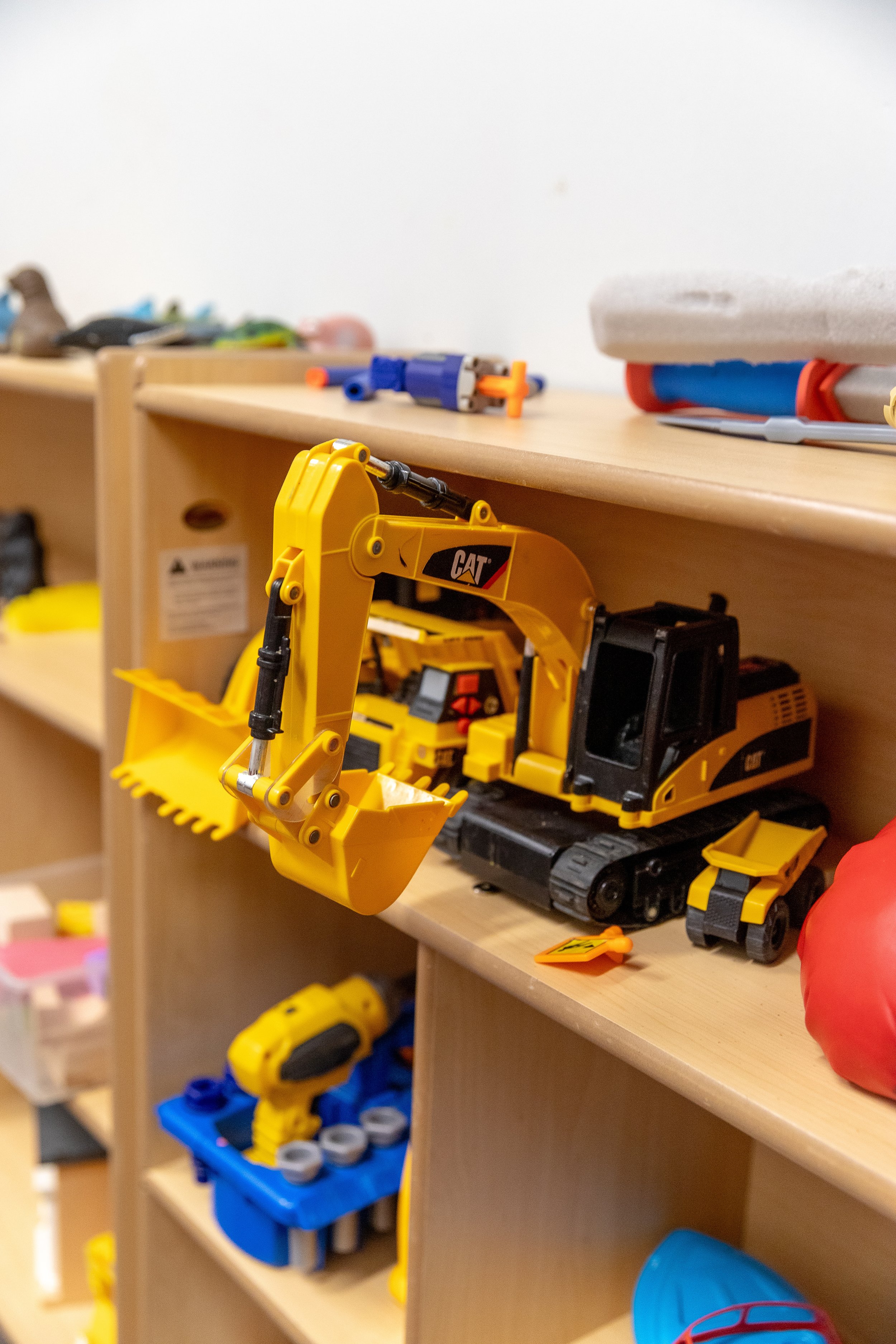 Shelf full of construction toys and vehicles.