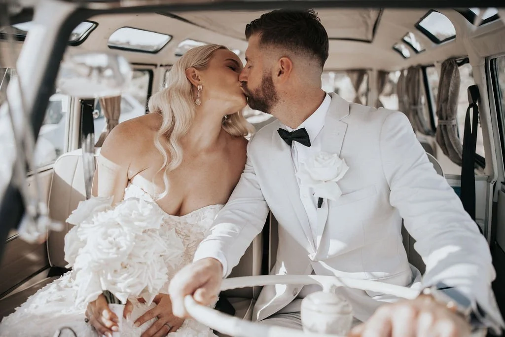 Blake and Miranda kissing inside their vintage wedding Kombi