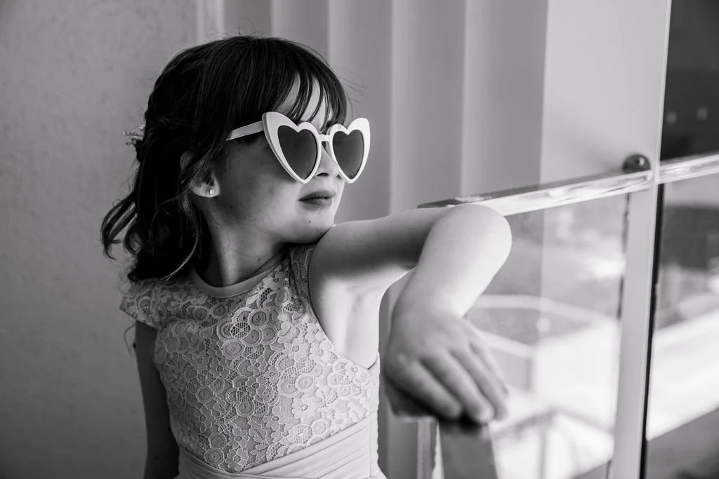 Young wedding guest wearing heart-shaped sunglasses during Erica and Chris’s wedding