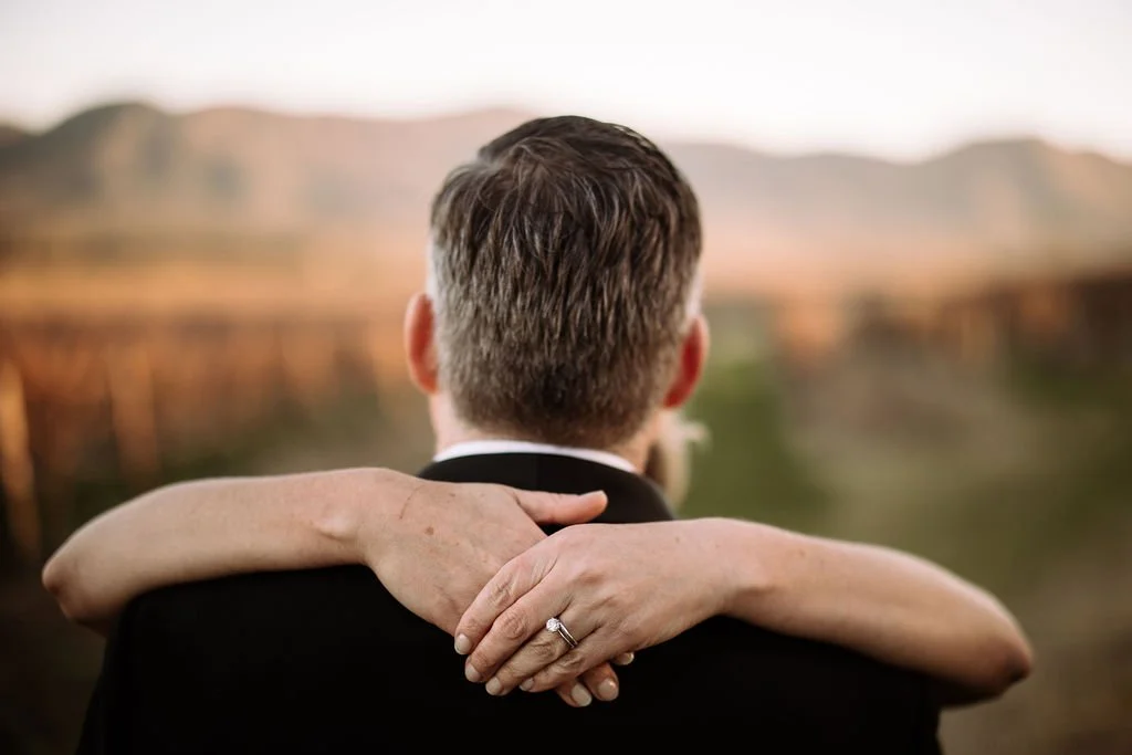 Close-up of Kate’s hands around Brendon during their wedding portrait session