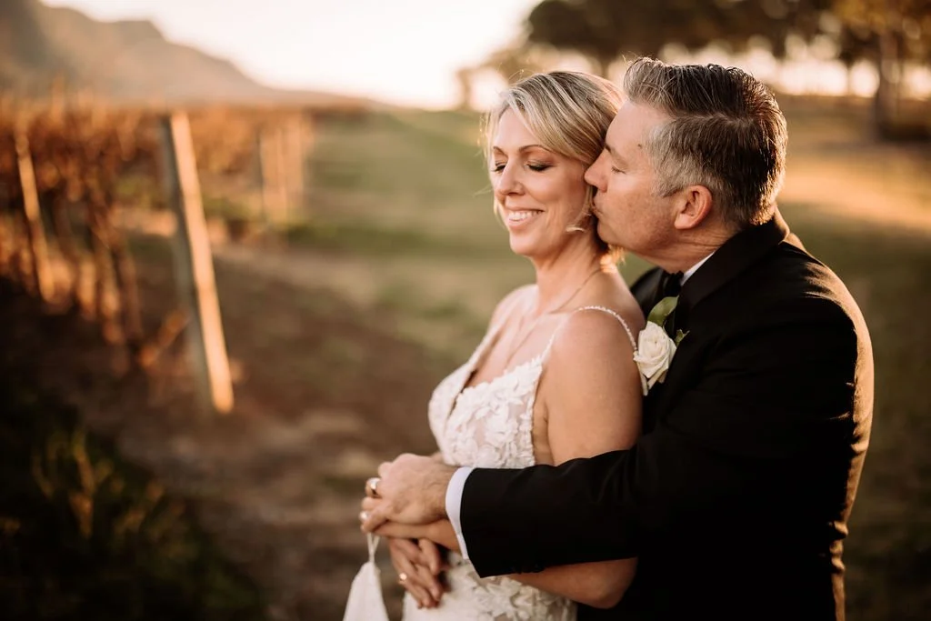 Brendon kissing Kate during warm sunset wedding portraits